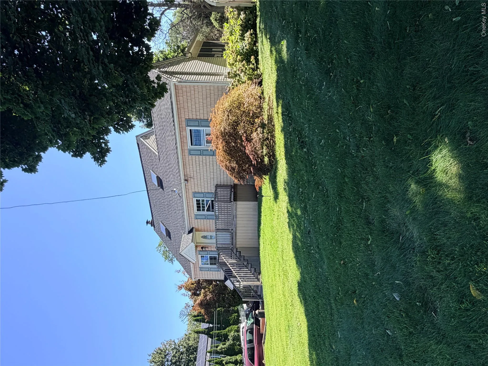 Shingle-sided residence with a covered porch, front steps, and a gabled dormer roof Shingle-sided residence with a covered porch, front steps, and a gabled dormer roof