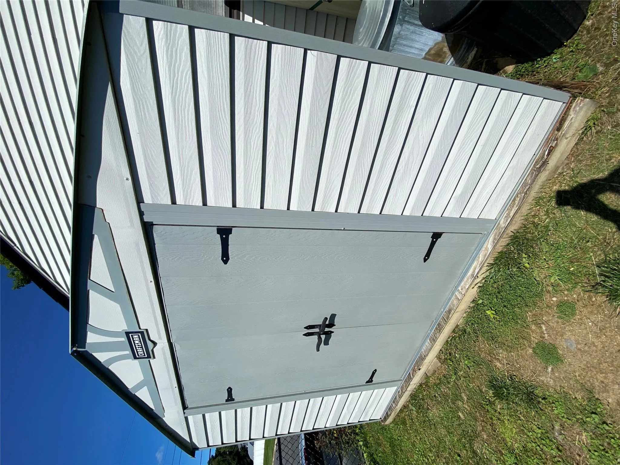 Detached storage shed featuring vinyl siding and double entry doors with black hardware Detached storage shed featuring vinyl siding and double entry doors with black hardware