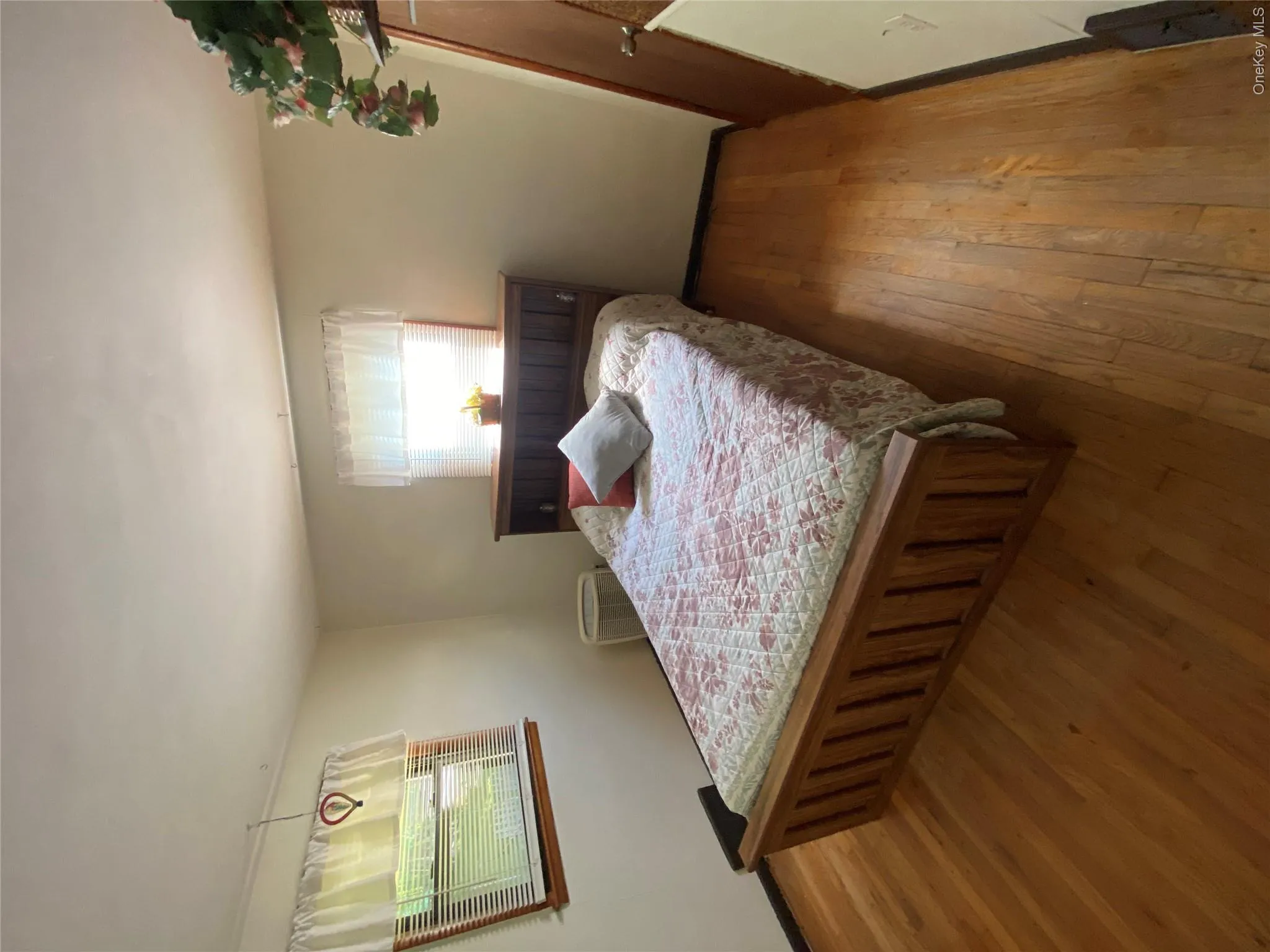 Hardwood flooring, painted walls, two windows with blinds, and a built-in wooden headboard Hardwood flooring, painted walls, two windows with blinds, and a built-in wooden headboard