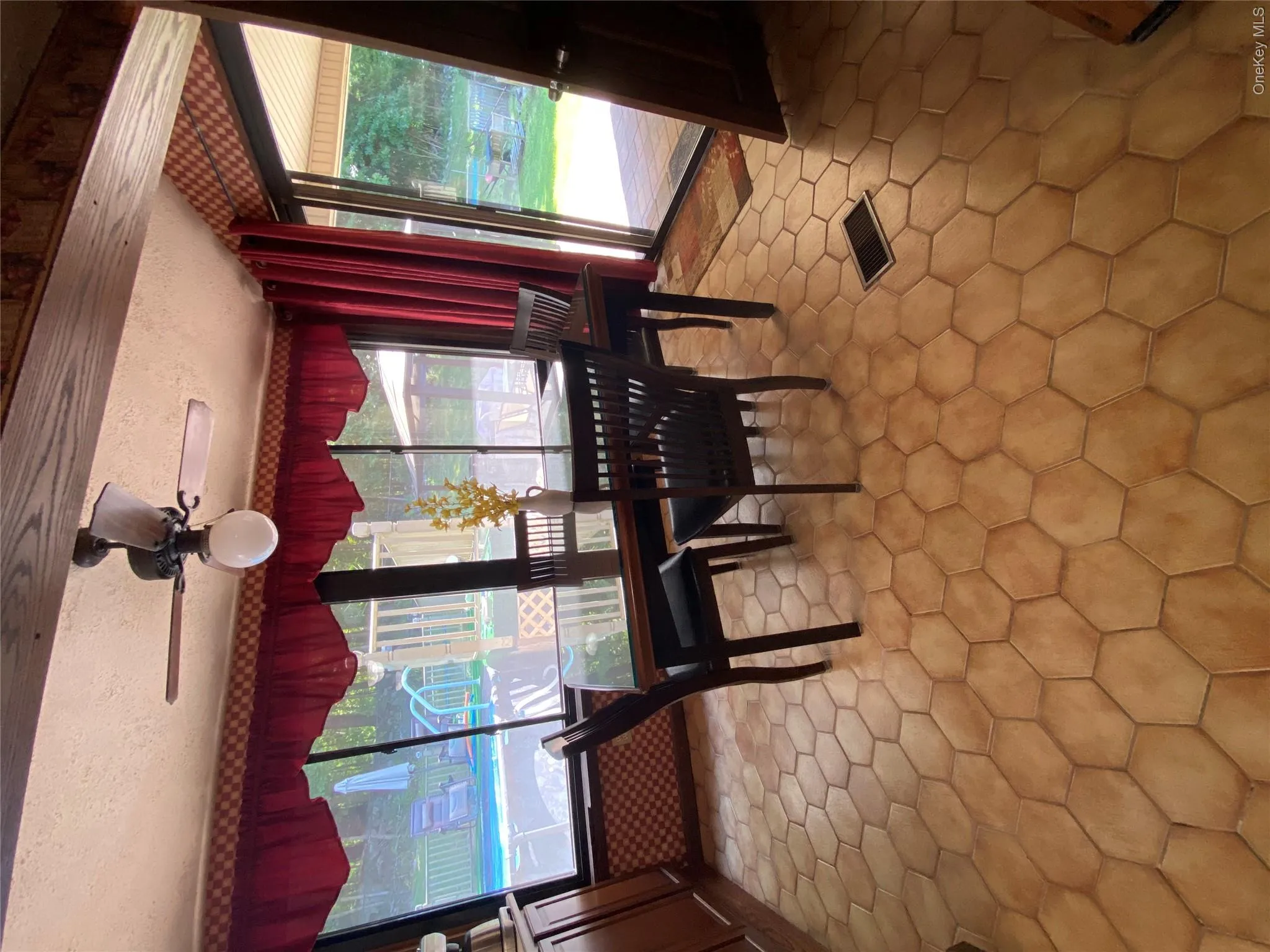 Room with hexagonal tile flooring, wood-finish ceiling beams, and a ceiling fan with integrated lighting Room with hexagonal tile flooring, wood-finish ceiling beams, and a ceiling fan with integrated lighting