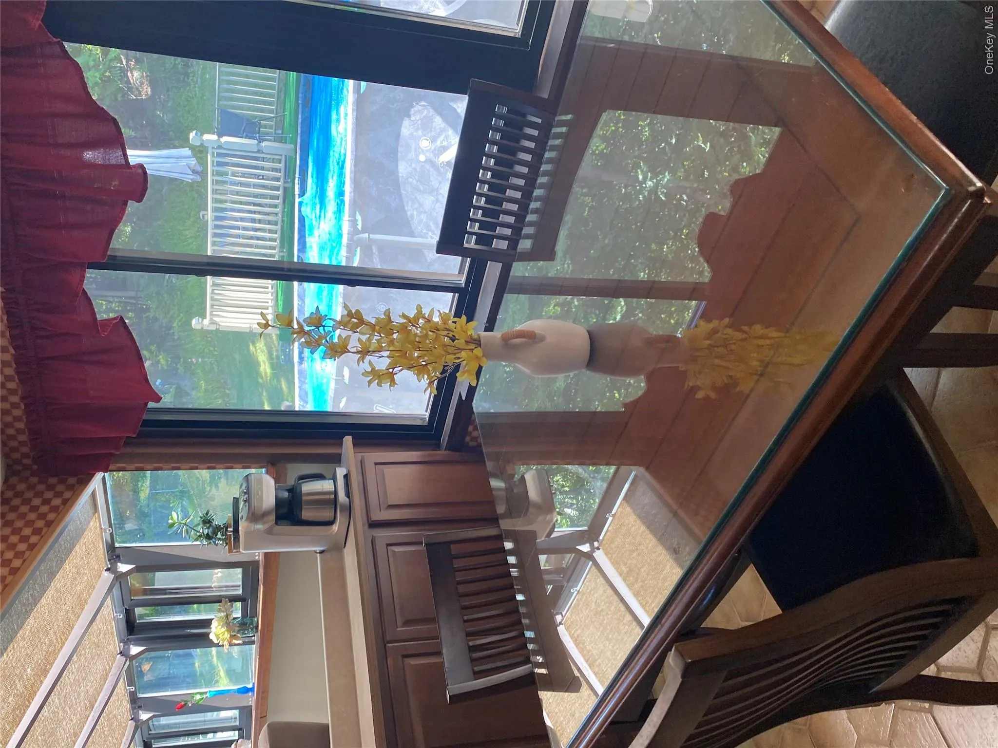 Dining area featuring full-height windows, a built-in counter with cabinetry, and a visible outdoor pool Dining area featuring full-height windows, a built-in counter with cabinetry, and a visible outdoor pool