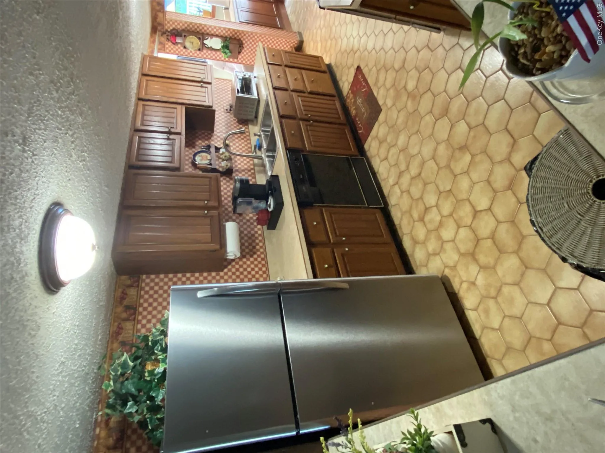 Kitchen featuring a double basin sink, dark wood-finish cabinetry, hexagon tile flooring, and a flush mount ceiling light fixture Kitchen featuring a double basin sink, dark wood-finish cabinetry, hexagon tile flooring, and a flush mount ceiling light fixture