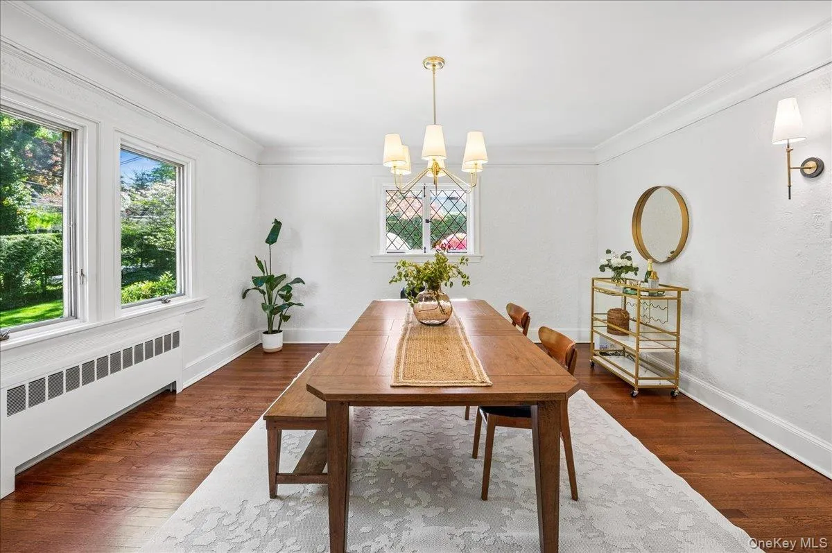 Spacious dining room with hardwood flooring, crown molding, and large windows Spacious dining room with hardwood flooring, crown molding, and large windows