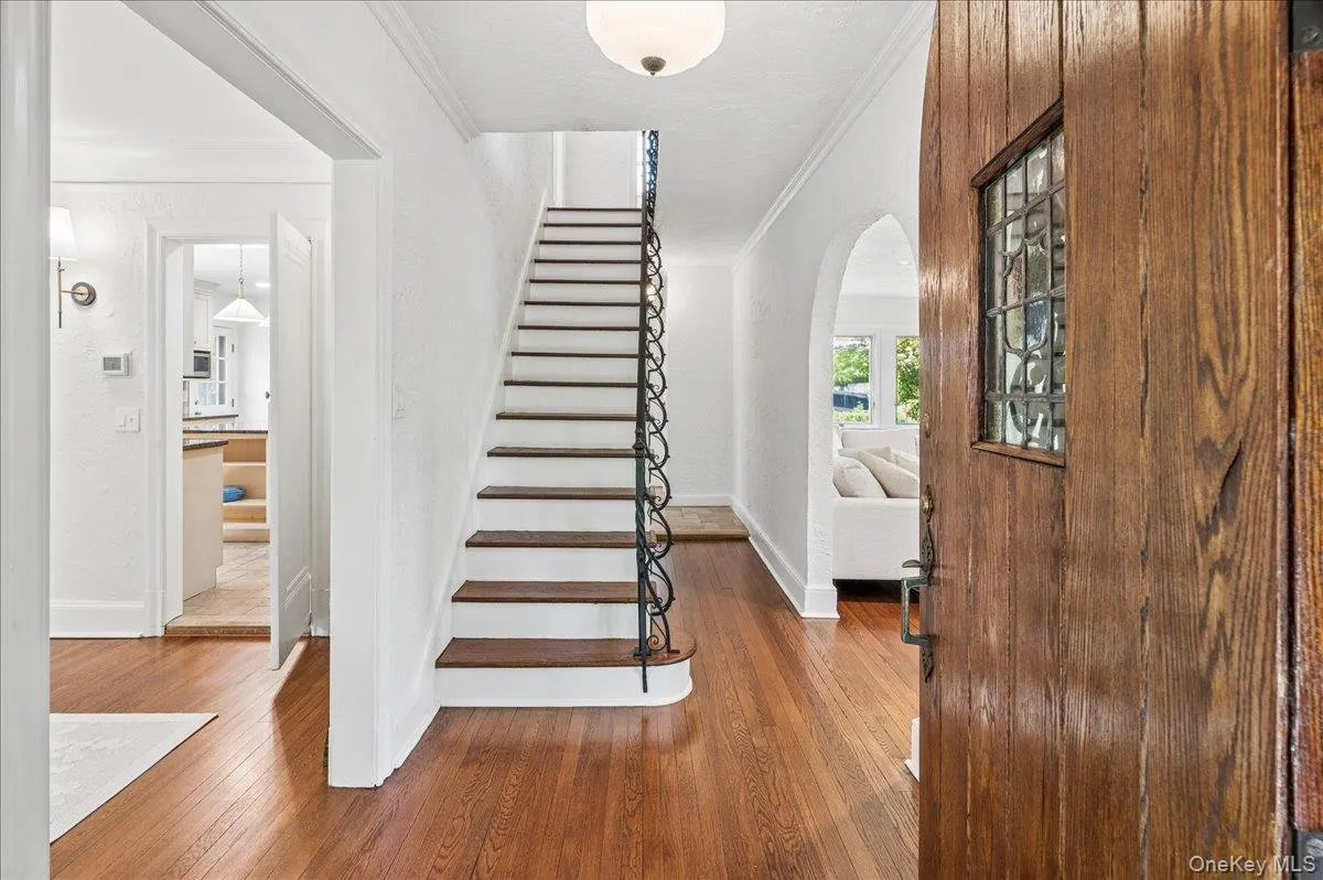 Hardwood flooring throughout, featuring a classic staircase with wrought iron balusters Hardwood flooring throughout, featuring a classic staircase with wrought iron balusters