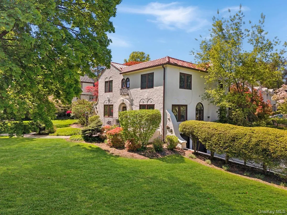 Stucco exterior with a terra cotta tile roof, arched entryway, second-story balcony, and dark-framed windows Stucco exterior with a terra cotta tile roof, arched entryway, second-story balcony, and dark-framed windows