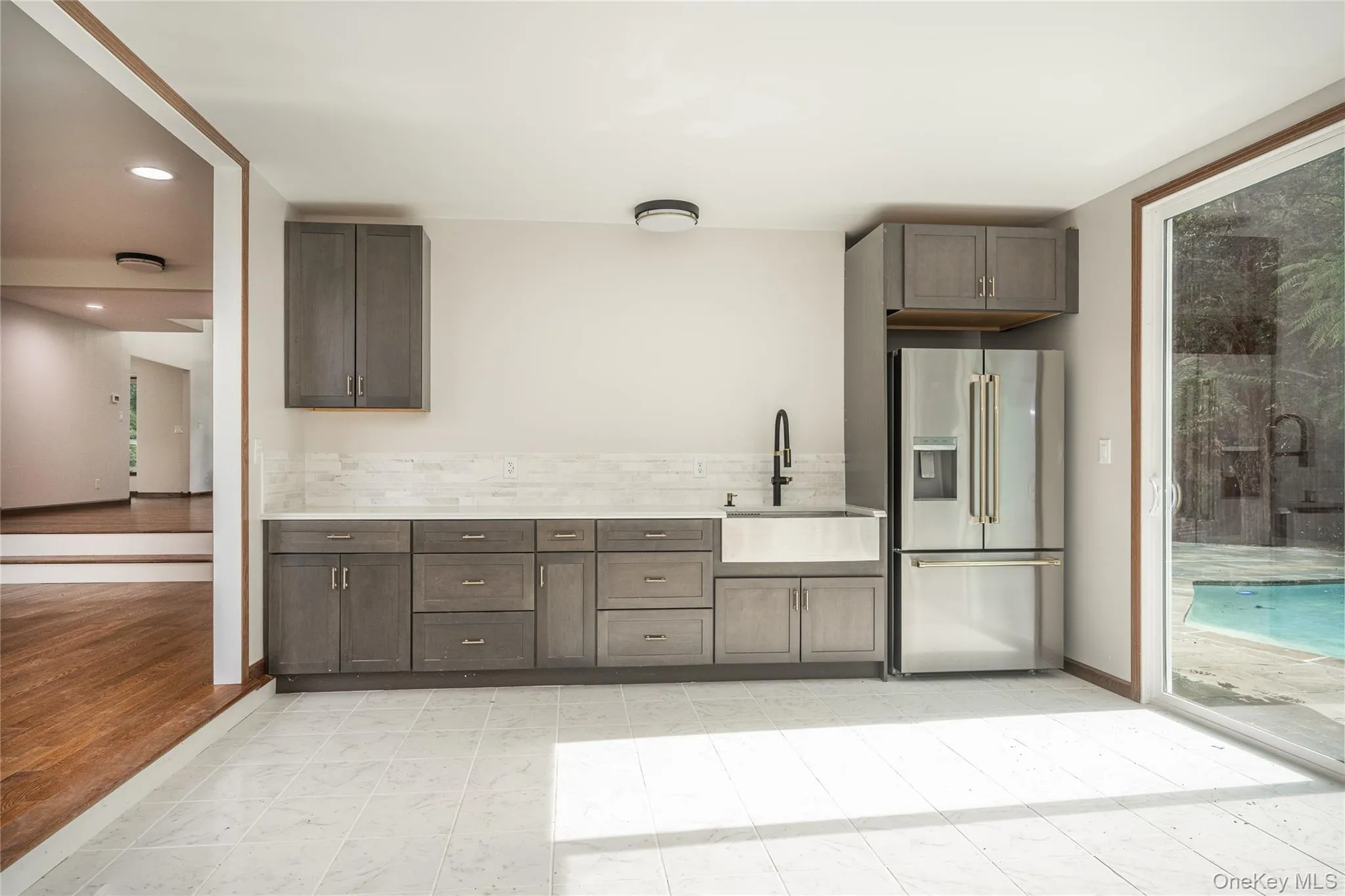 Located on the first floor. The living room is to the left and 2 sliding doors lead out to the pool on the right. Nice empty spot on the wall to accommodate a large screen. Located on the first floor. The living room is to the left and 2 sliding doors lead out to the pool on the right. Nice empty spot on the wall to accommodate a large screen.