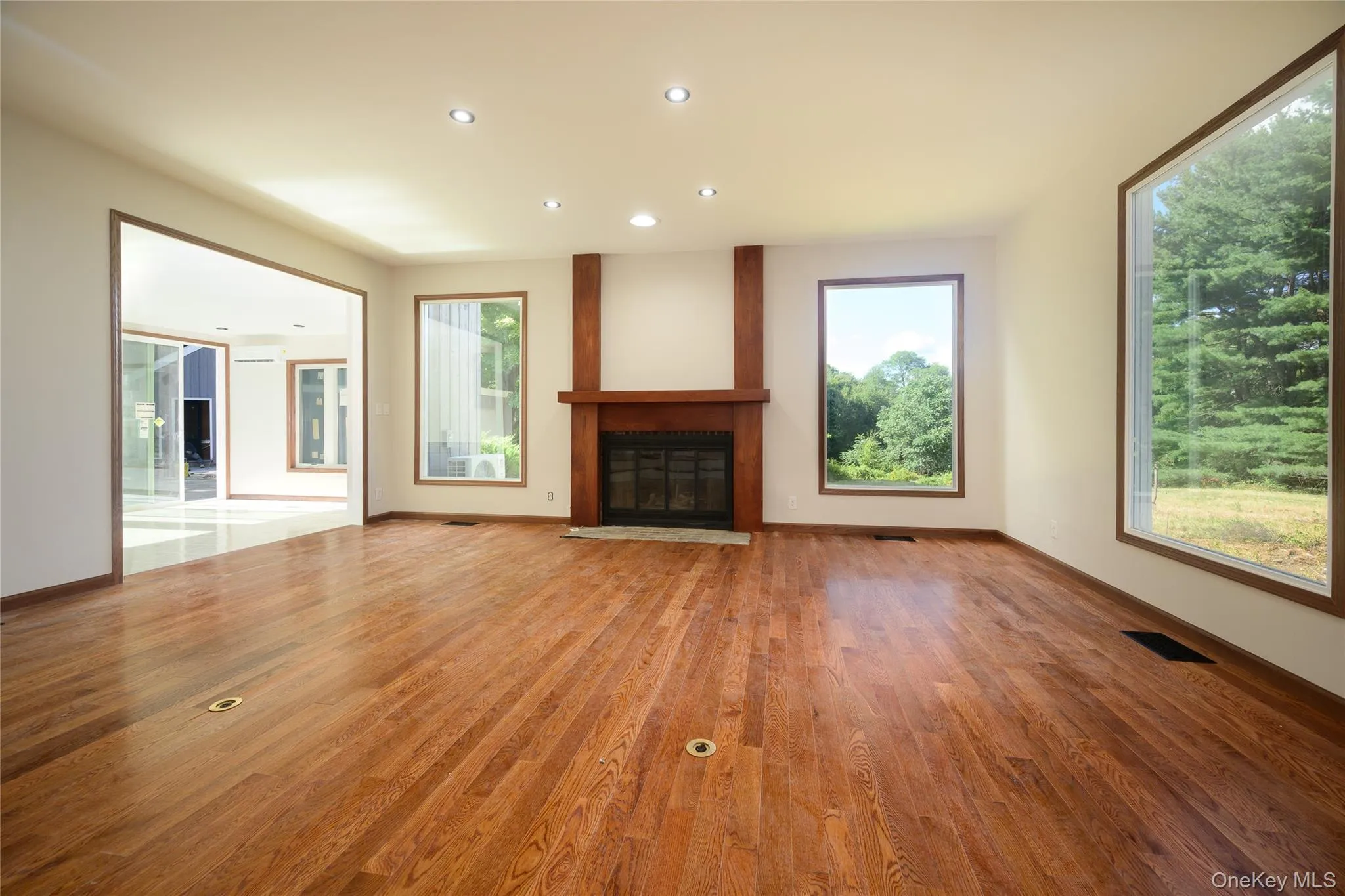 The living room featuring three picture windows, one of the 5 propane fired fire-places and it opens to the sunroom which leads to the pool. Brand new Oak flooring here and in every other room that is not tiled. The living room featuring three picture windows, one of the 5 propane fired fire-places and it opens to the sunroom which leads to the pool. Brand new Oak flooring here and in every other room that is not tiled.