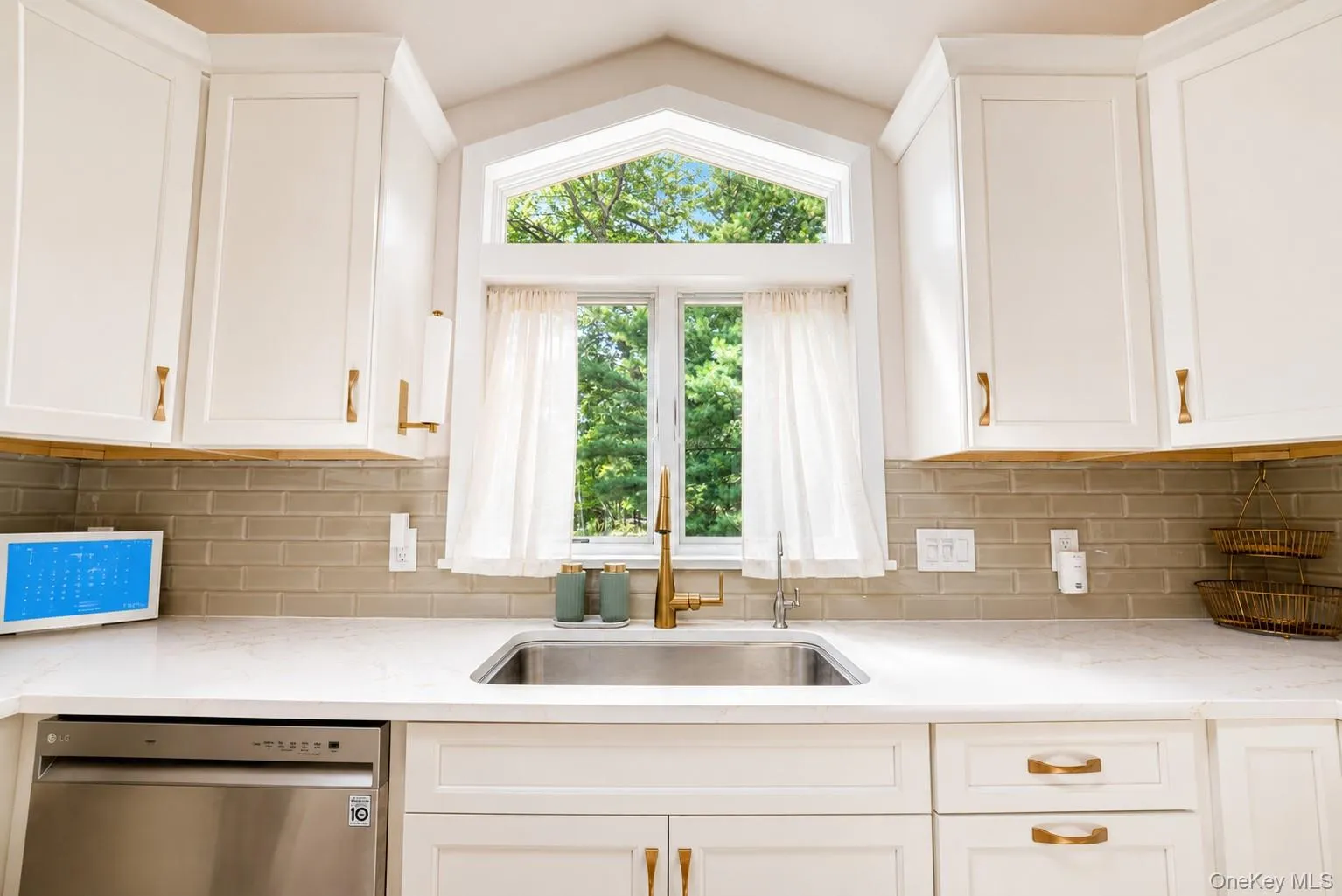 The kitchen is beautifully appointed with elegant natural quartz countertops and stylish gold accents, adding a sophisticated touch to this thoughtfully updated space. The kitchen is beautifully appointed with elegant natural quartz countertops and stylish gold accents, adding a sophisticated touch to this thoughtfully updated space.