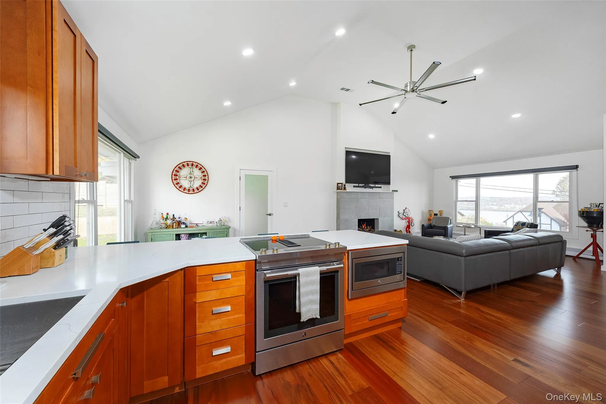 Kitchen with brown cabinetry, appliances with stainless steel finishes, a peninsula, dark wood-type flooring, and open floor plan Kitchen with brown cabinetry, appliances with stainless steel finishes, a peninsula, dark wood-type flooring, and open floor plan