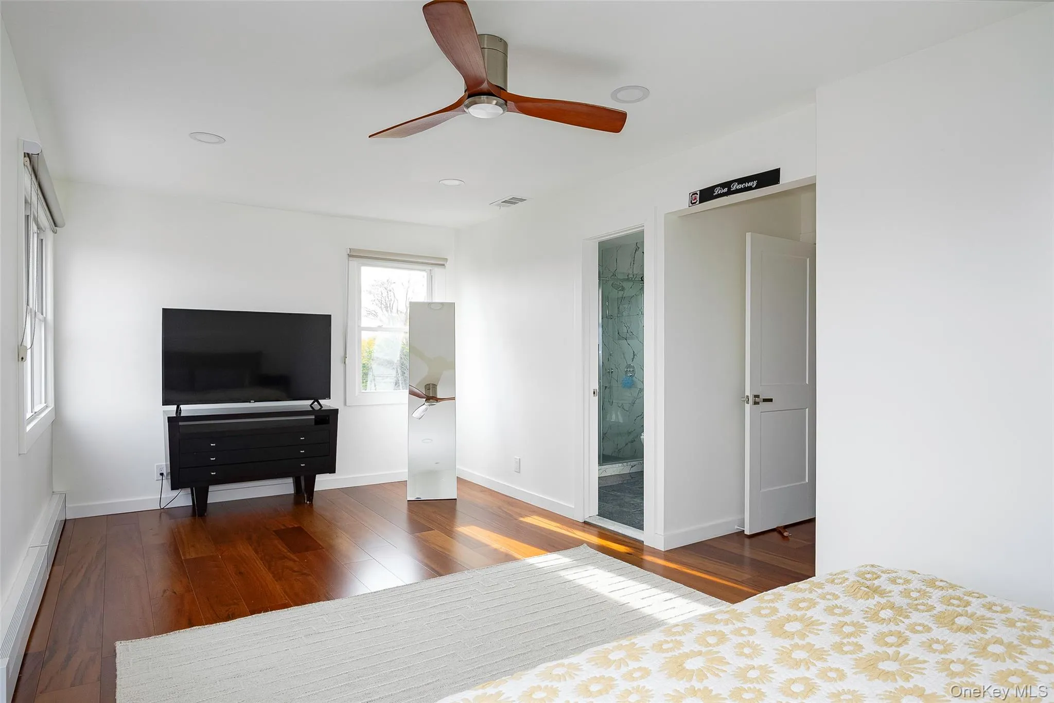 Bedroom with dark wood-style flooring, a baseboard heating unit, a ceiling fan, recessed lighting, and ensuite bath Bedroom with dark wood-style flooring, a baseboard heating unit, a ceiling fan, recessed lighting, and ensuite bath