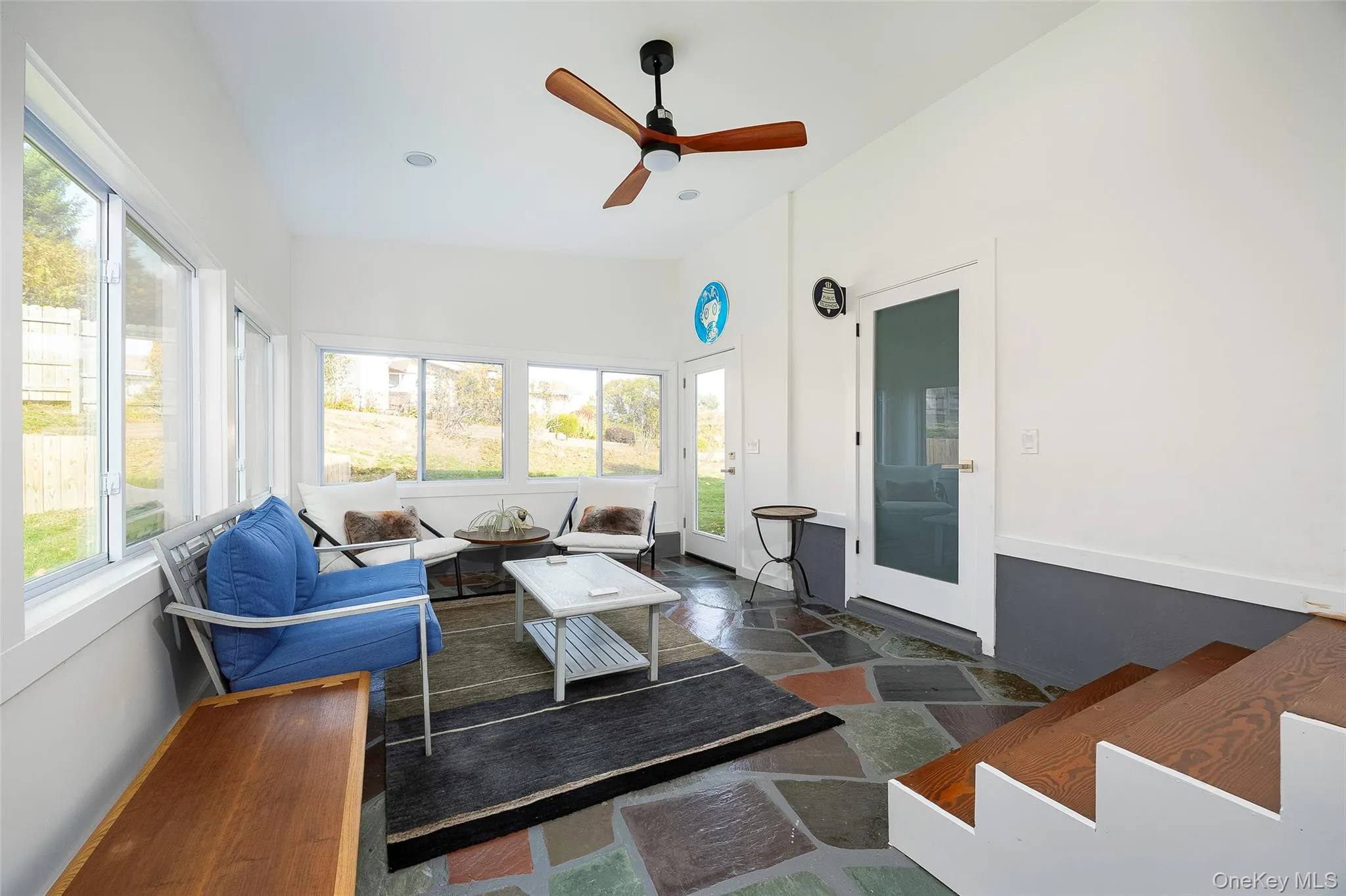 Sunroom with outdoor lounge area, stone tile floors, a ceiling fan, and recessed lighting Sunroom with outdoor lounge area, stone tile floors, a ceiling fan, and recessed lighting