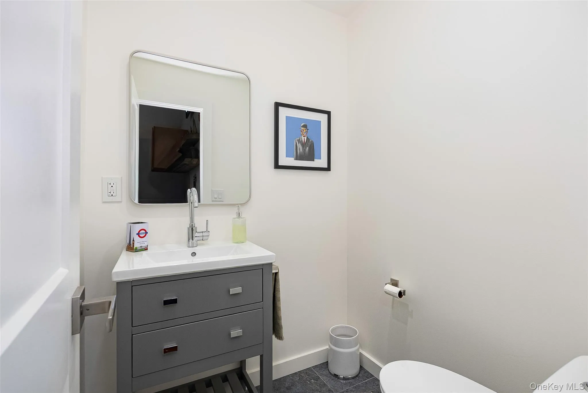 Half bath featuring vanity and dark tile patterned flooring Half bath featuring vanity and dark tile patterned flooring