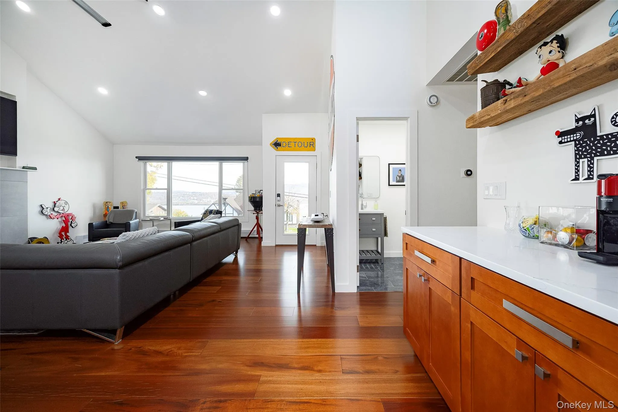 Kitchen featuring brown cabinets, dark wood-style flooring, high vaulted ceiling, recessed lighting, and open floor plan Kitchen featuring brown cabinets, dark wood-style flooring, high vaulted ceiling, recessed lighting, and open floor plan