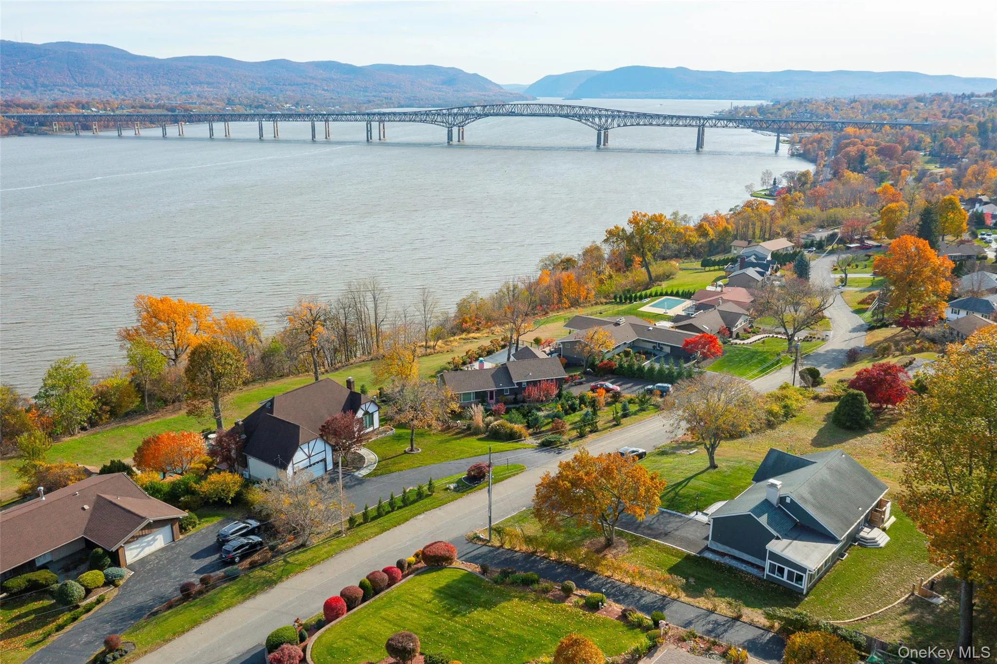 Aerial perspective of suburban area with a notable bridge and a water and mountain view Aerial perspective of suburban area with a notable bridge and a water and mountain view