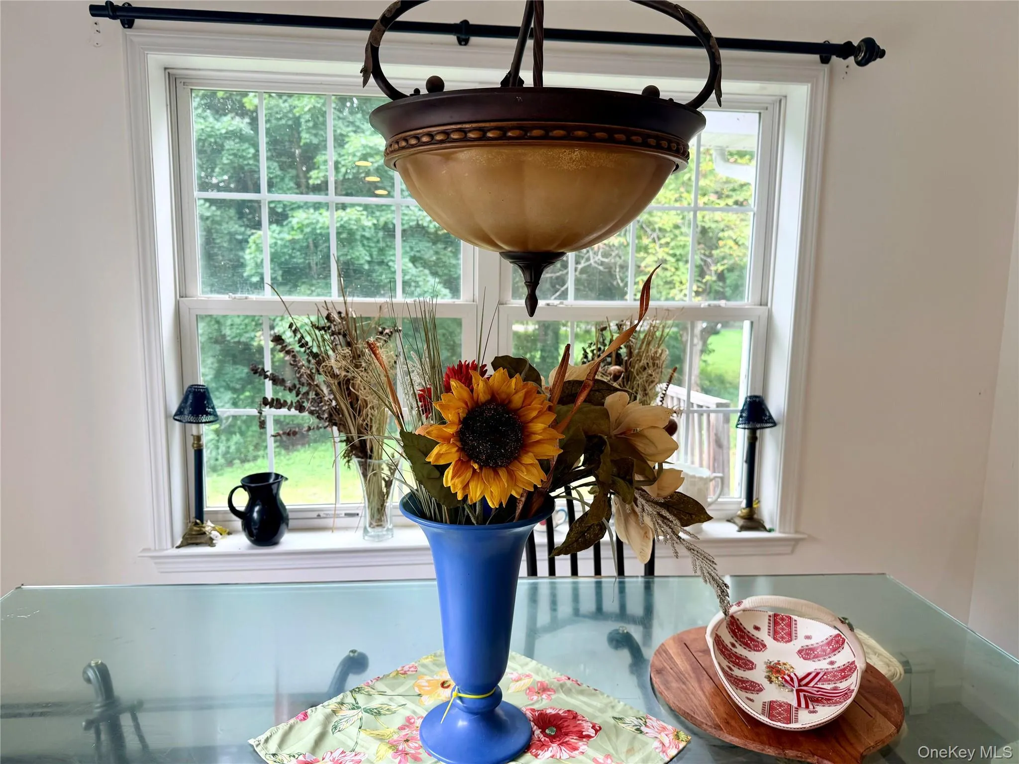 Expansive window with sash detailing, overhead chandelier fixture, and ceiling-mounted drapery rod Expansive window with sash detailing, overhead chandelier fixture, and ceiling-mounted drapery rod