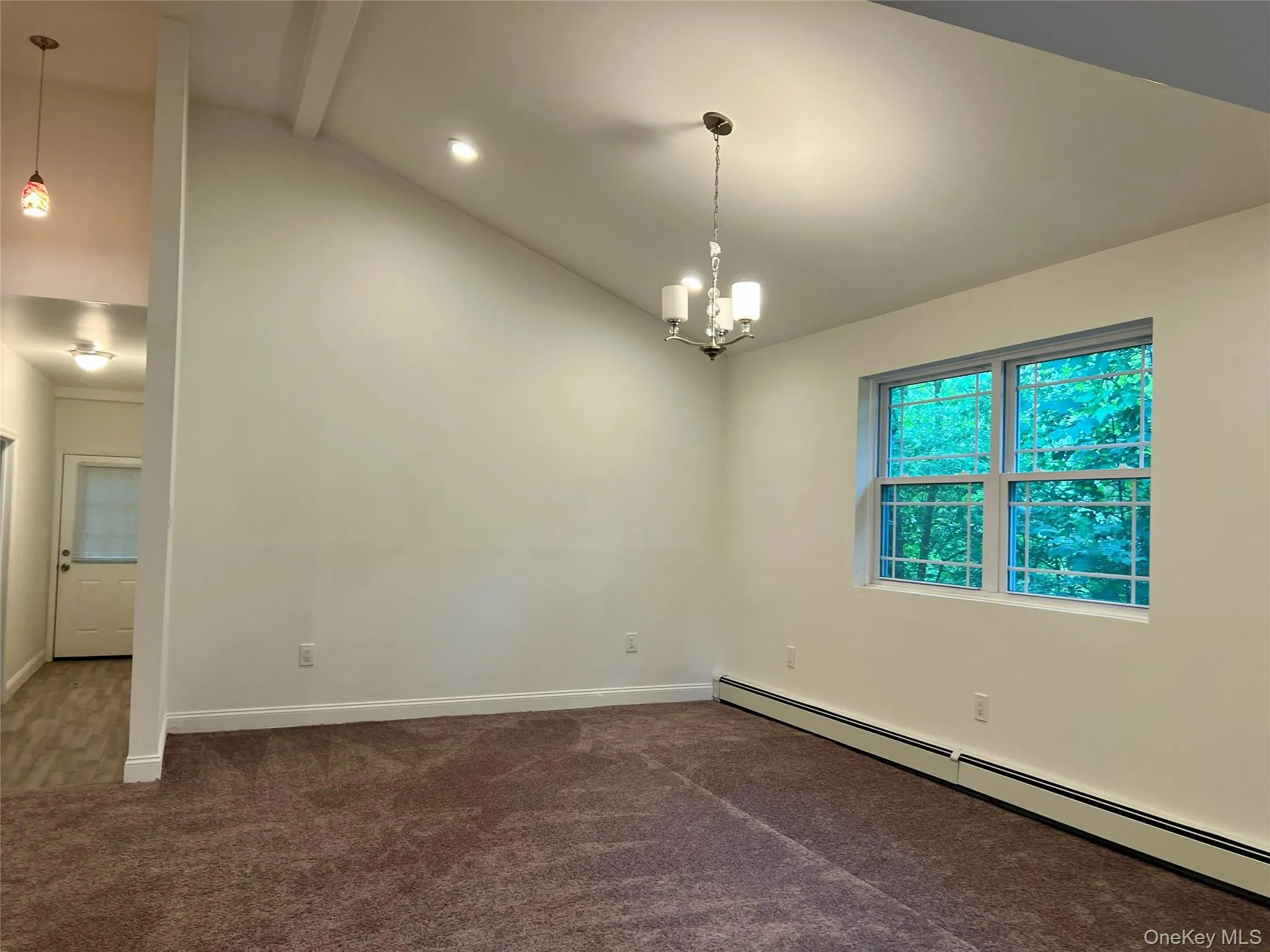 Unfurnished room featuring a baseboard heating unit, dark carpet, and a chandelier Unfurnished room featuring a baseboard heating unit, dark carpet, and a chandelier