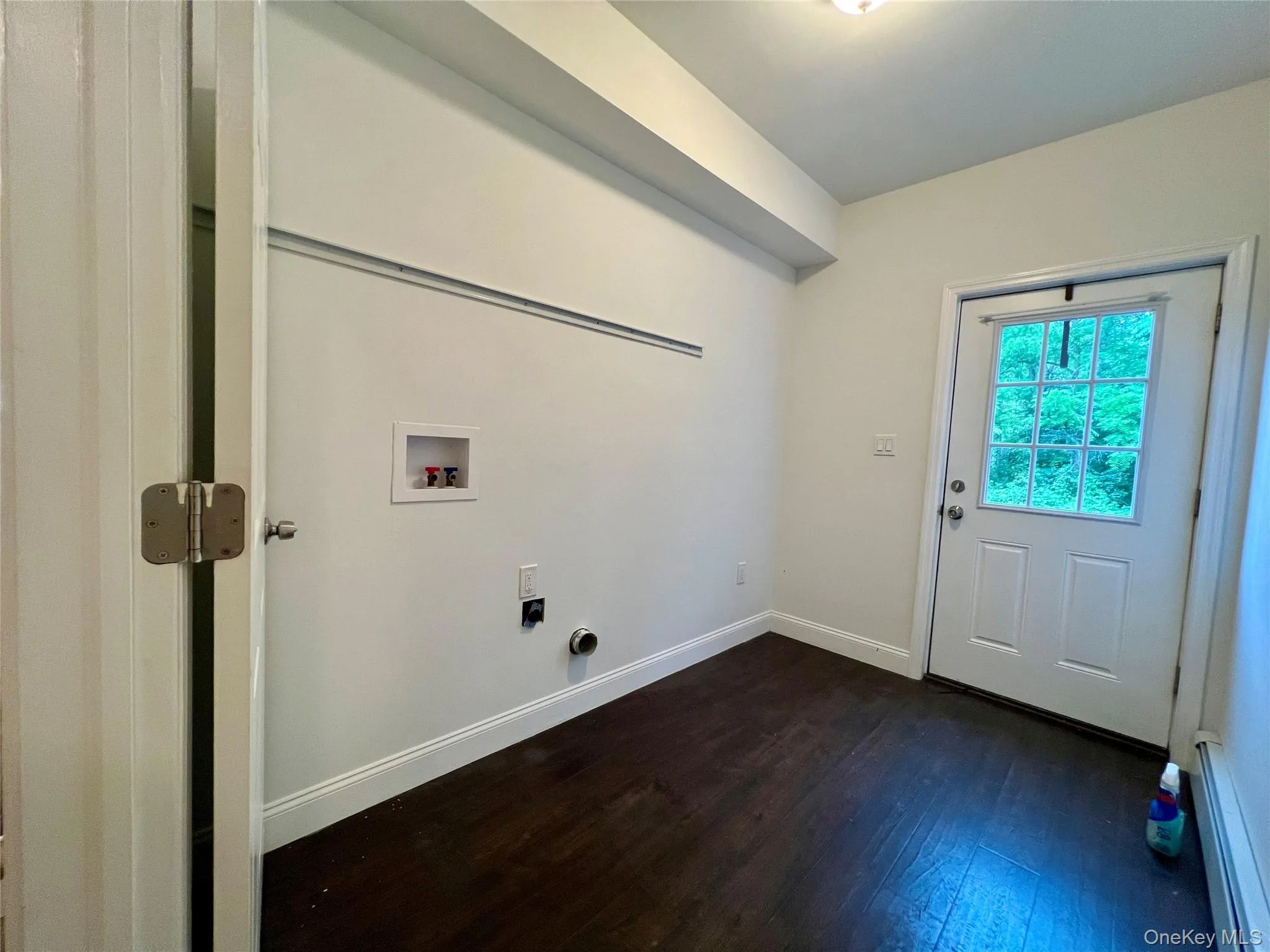 Laundry area featuring washer hookup, dark wood-style floors, baseboard heating, and hookup for an electric dryer Laundry area featuring washer hookup, dark wood-style floors, baseboard heating, and hookup for an electric dryer
