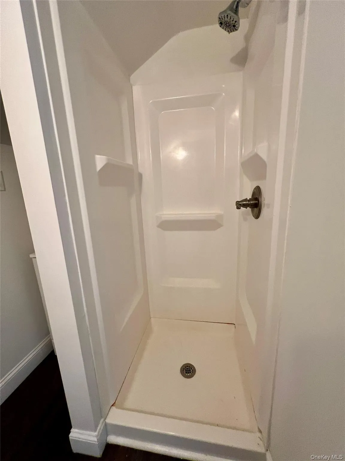 Full bath featuring a stall shower and wood finished floors Full bath featuring a stall shower and wood finished floors