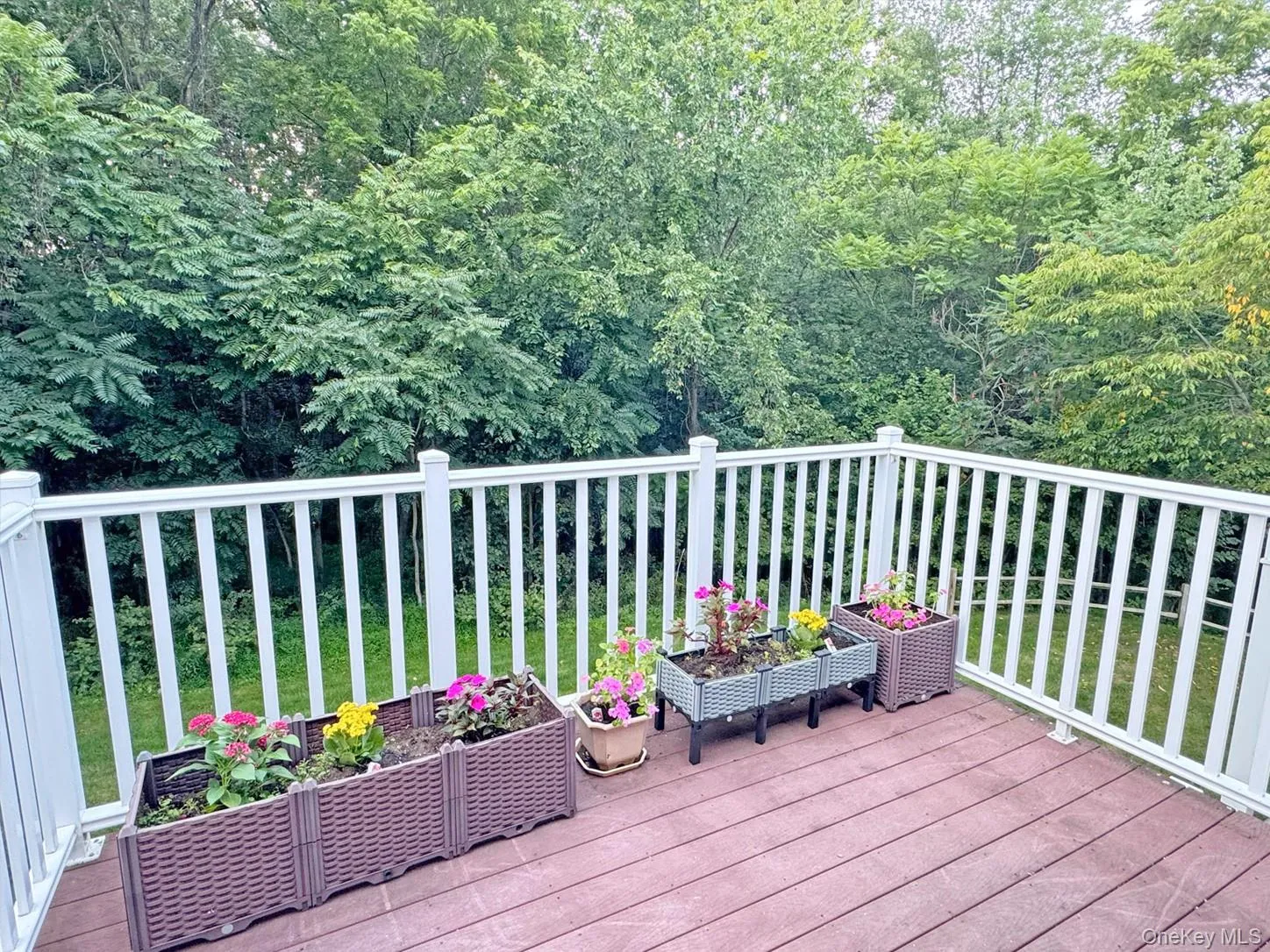 Outdoor deck featuring white composite railing and wood-finish decking Outdoor deck featuring white composite railing and wood-finish decking