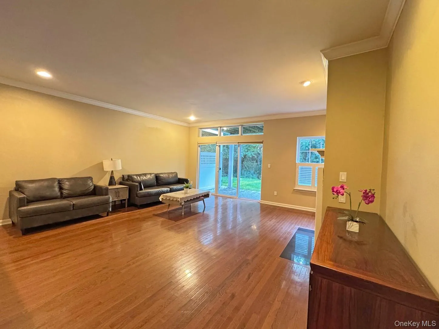 Wood-finish flooring, recessed lighting, crown molding, and sliding glass doors Wood-finish flooring, recessed lighting, crown molding, and sliding glass doors