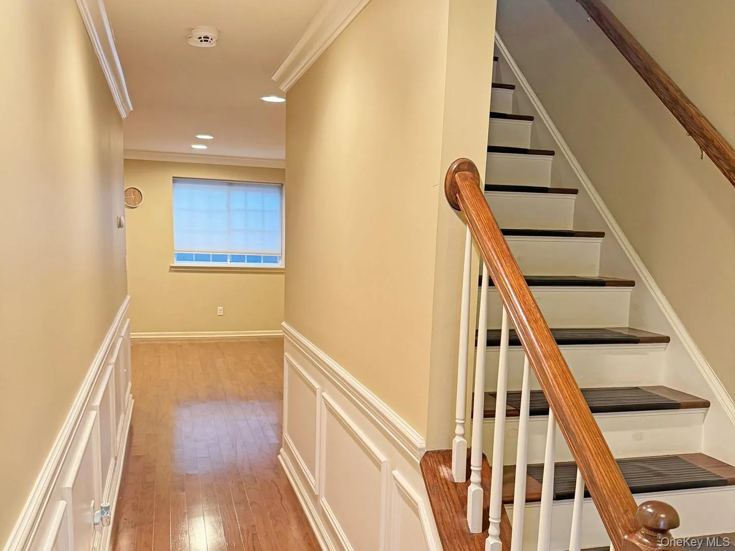 Hardwood flooring, crown molding, wainscoting, recessed lighting, and a window with blinds Hardwood flooring, crown molding, wainscoting, recessed lighting, and a window with blinds