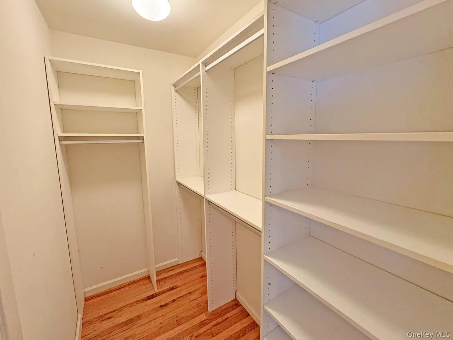 Built-in shelving, hanging rod, wood-finish flooring, recessed lighting, and crisp white walls Built-in shelving, hanging rod, wood-finish flooring, recessed lighting, and crisp white walls