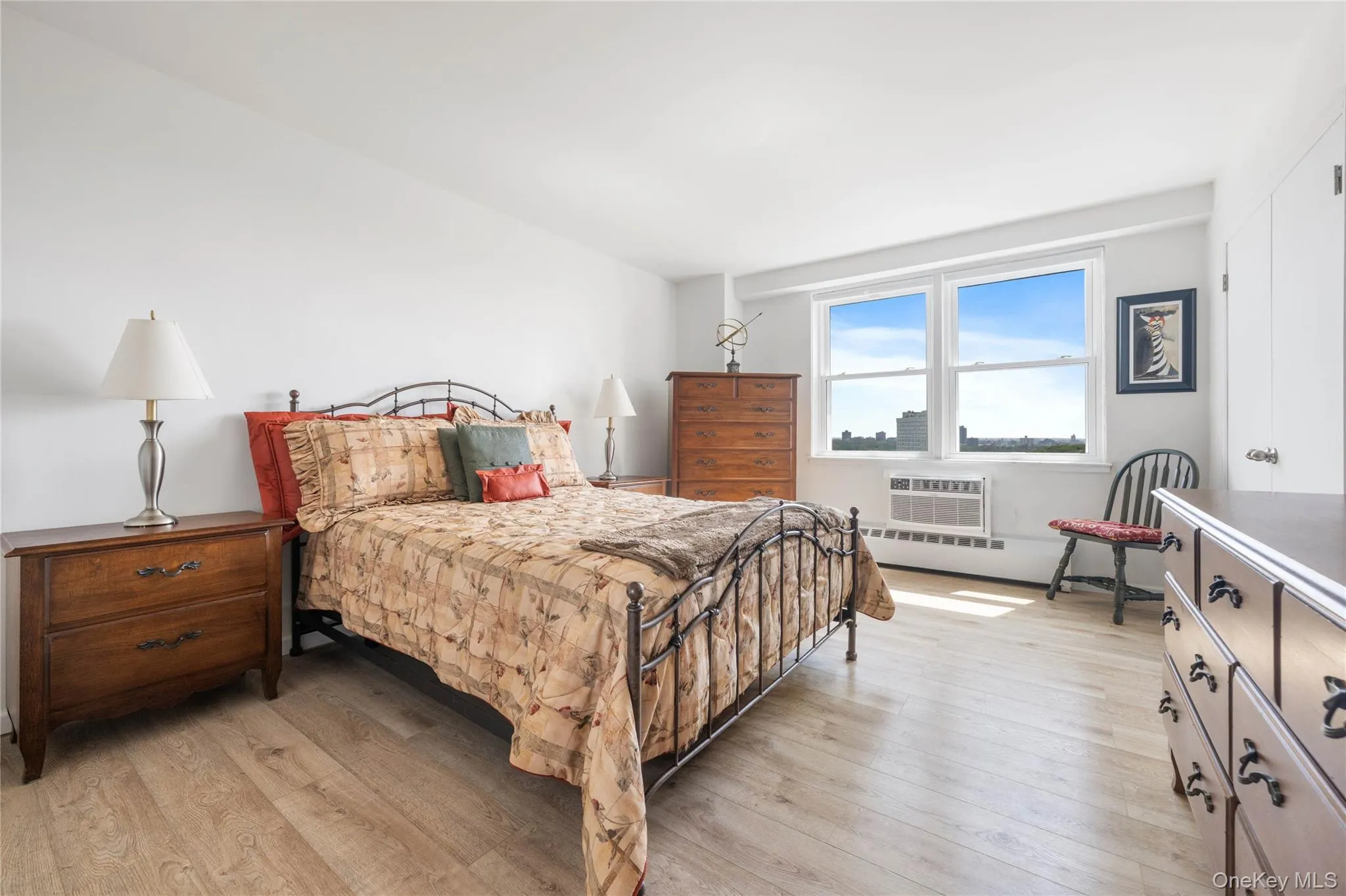 Light wood-finish flooring, white walls, large window, and built-in closet Light wood-finish flooring, white walls, large window, and built-in closet