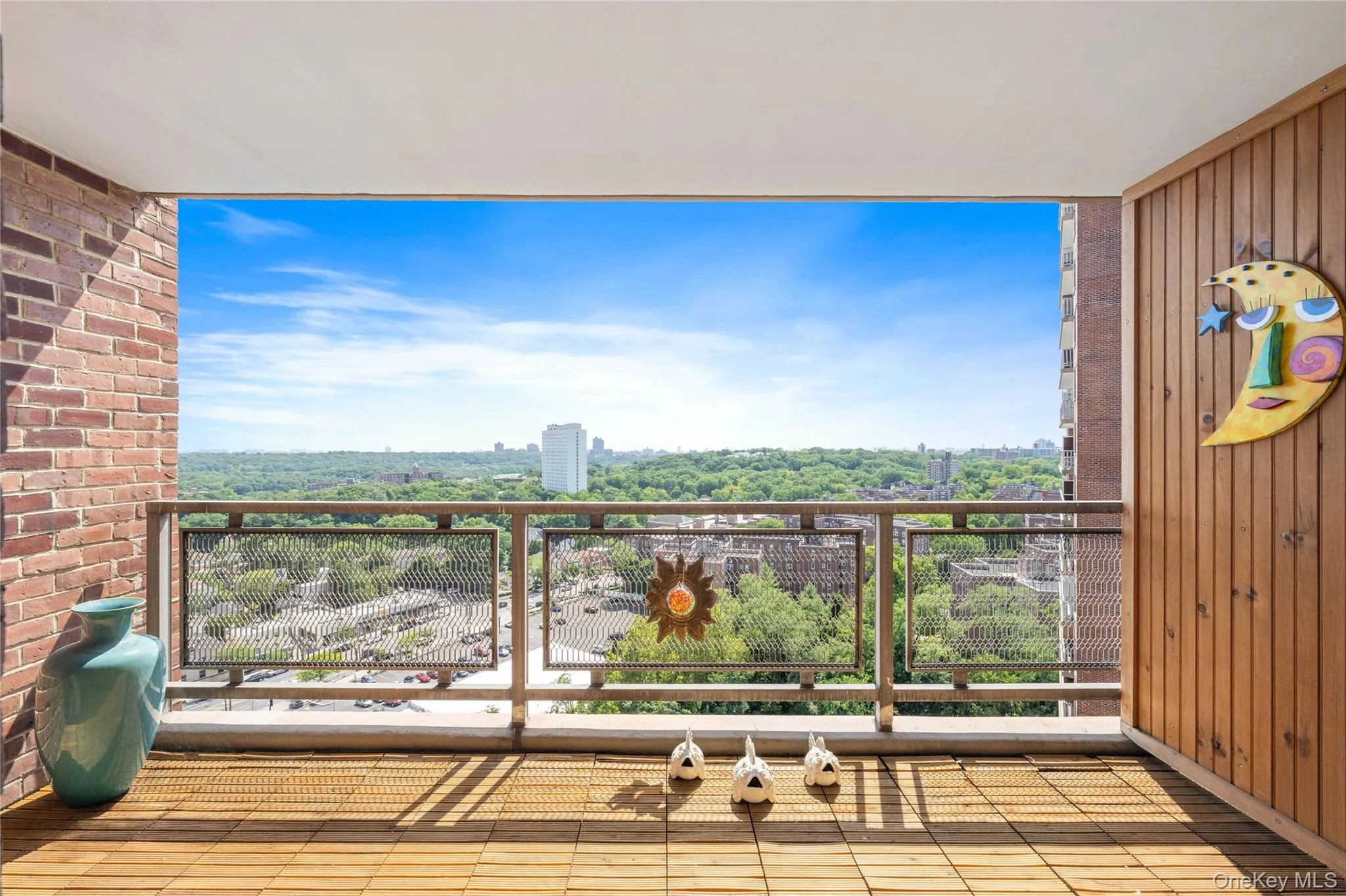 Balcony featuring brick and wood panel walls, a metal railing, and wood-finish flooring Balcony featuring brick and wood panel walls, a metal railing, and wood-finish flooring