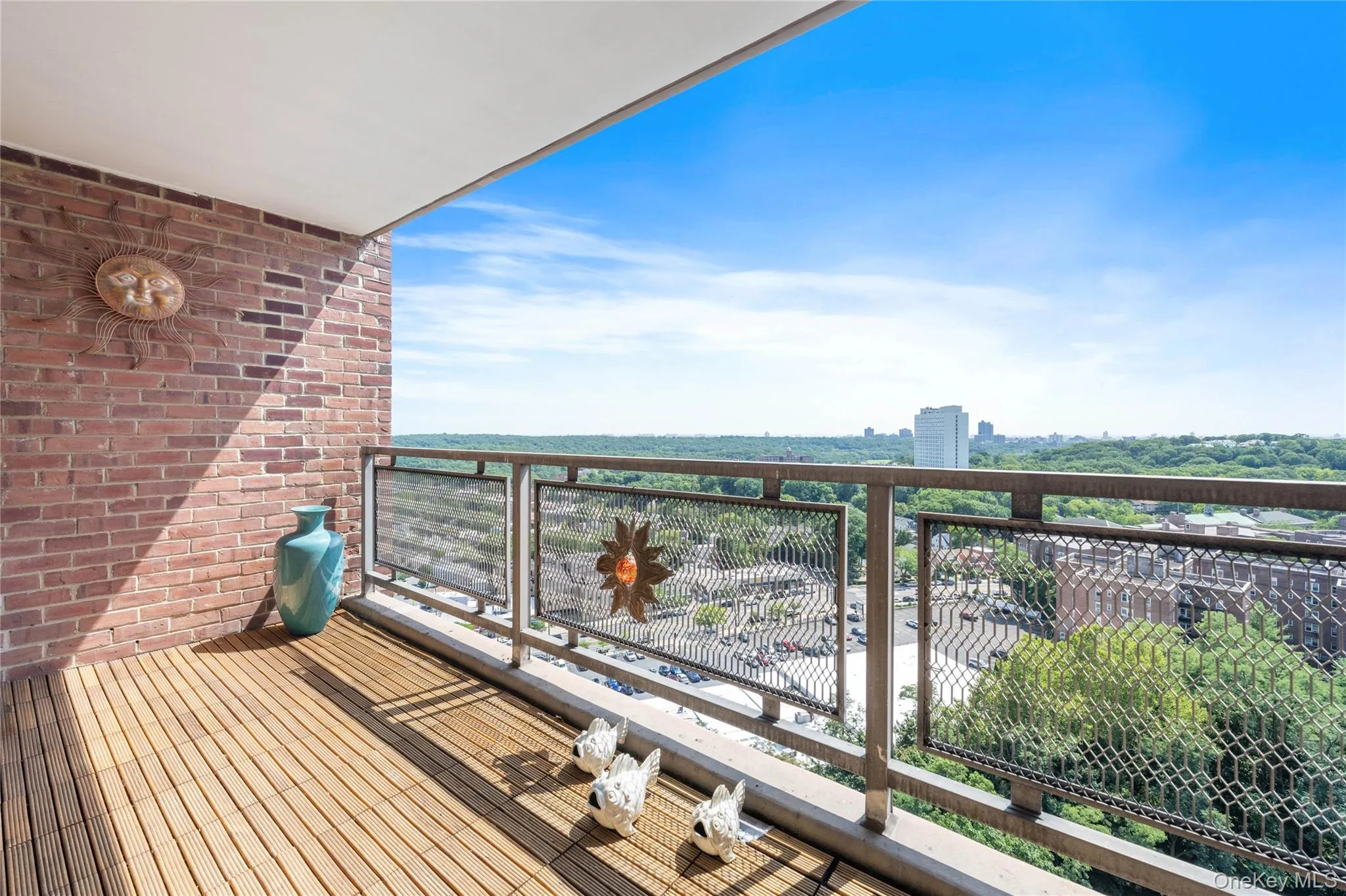 Balcony with slatted wood-finish flooring, brick wall, and metal railings Balcony with slatted wood-finish flooring, brick wall, and metal railings