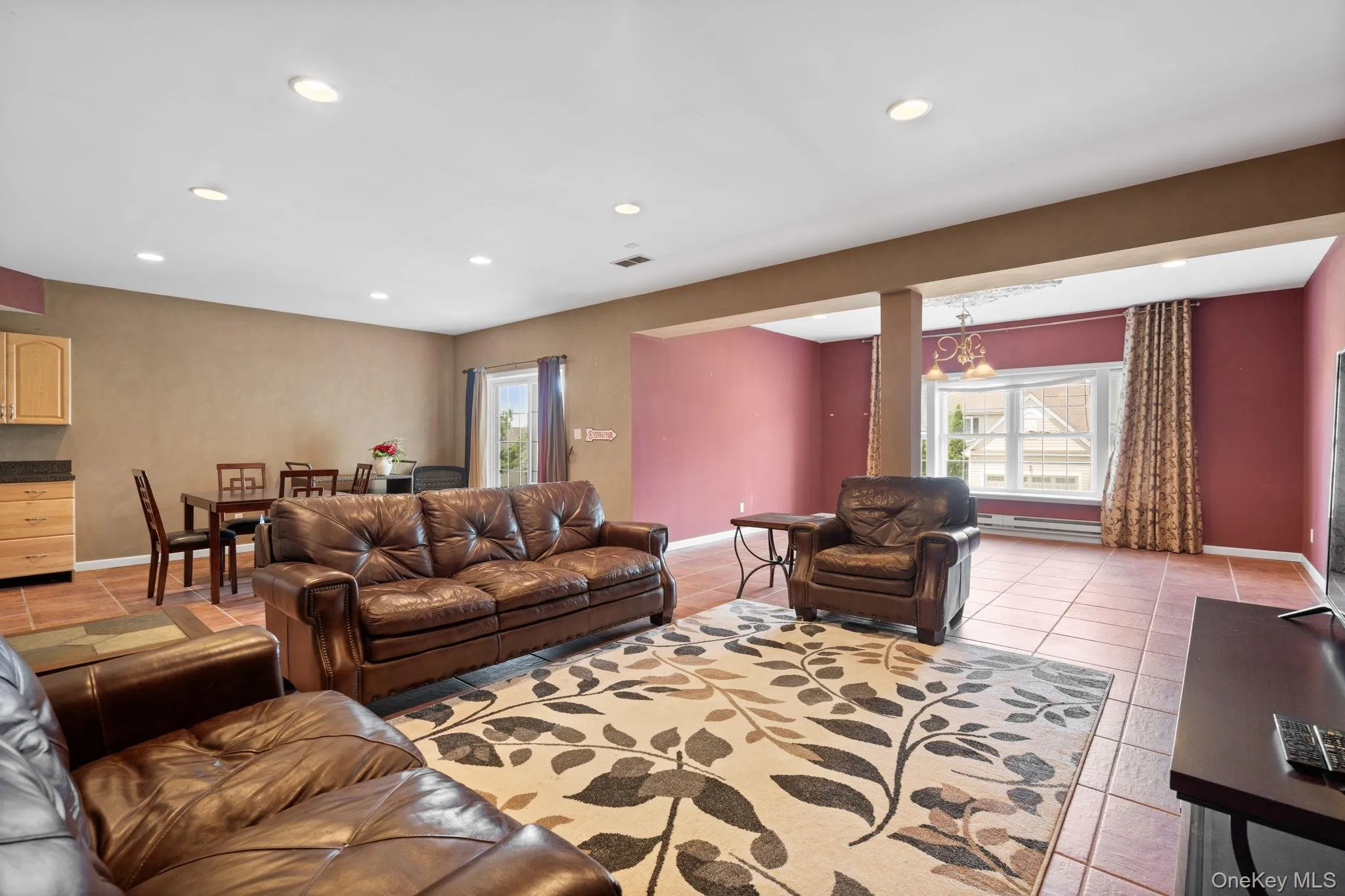Living area featuring healthy amount of natural light, recessed lighting, a baseboard radiator, and light tile patterned floors Living area featuring healthy amount of natural light, recessed lighting, a baseboard radiator, and light tile patterned floors