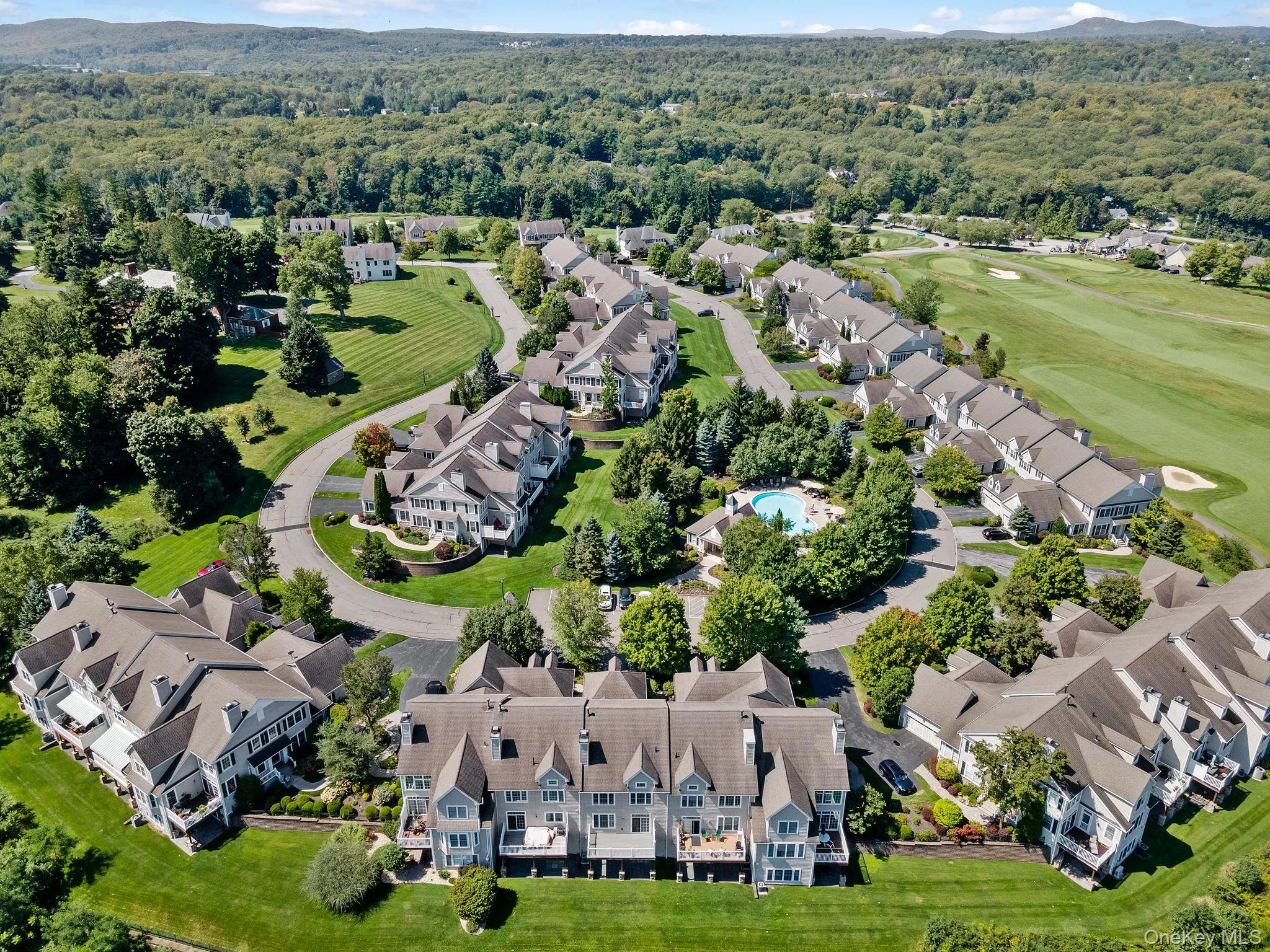 Aerial perspective of suburban area featuring a heavily wooded area and a golf club Aerial perspective of suburban area featuring a heavily wooded area and a golf club