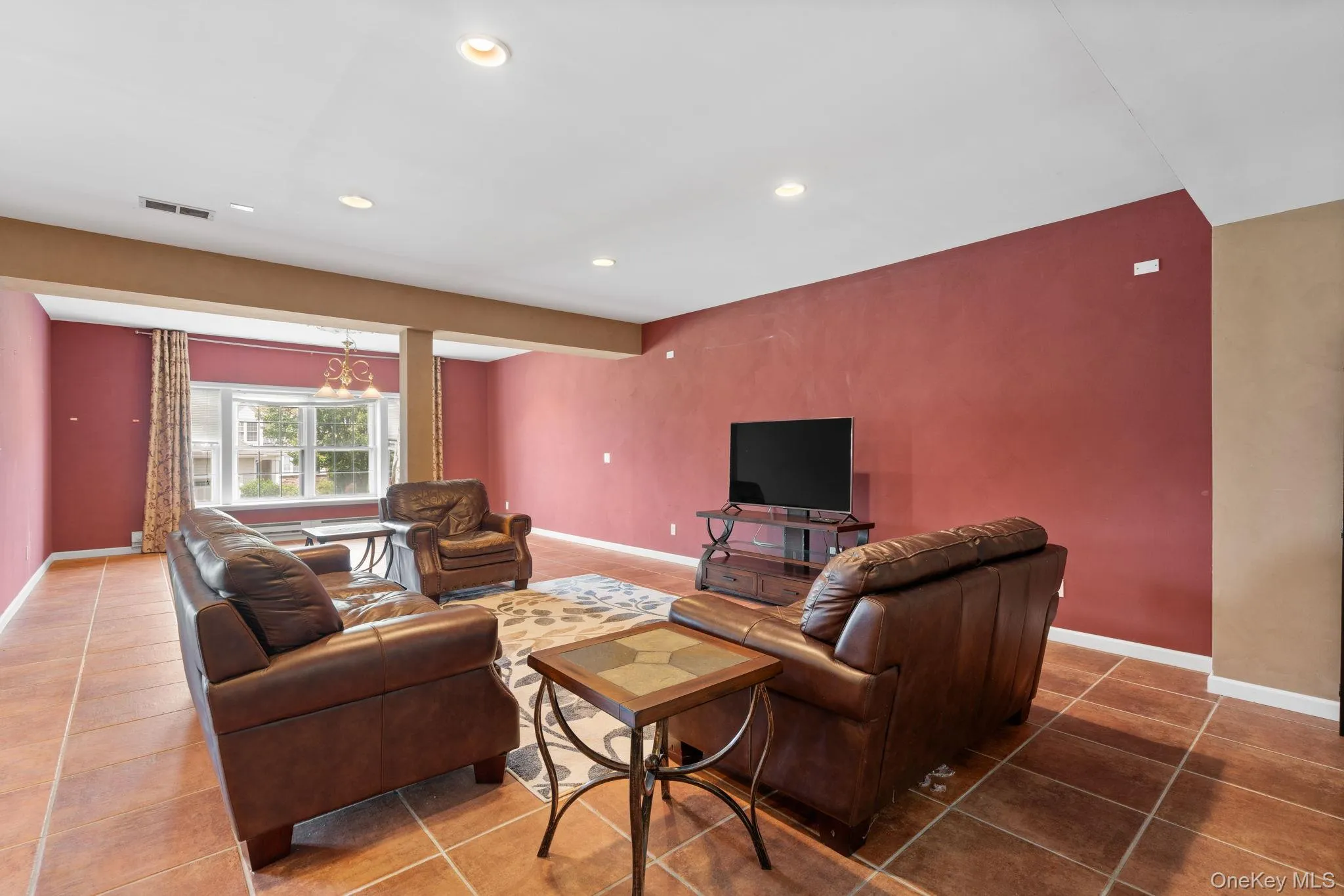 Tiled living room with an accent wall and recessed lighting Tiled living room with an accent wall and recessed lighting