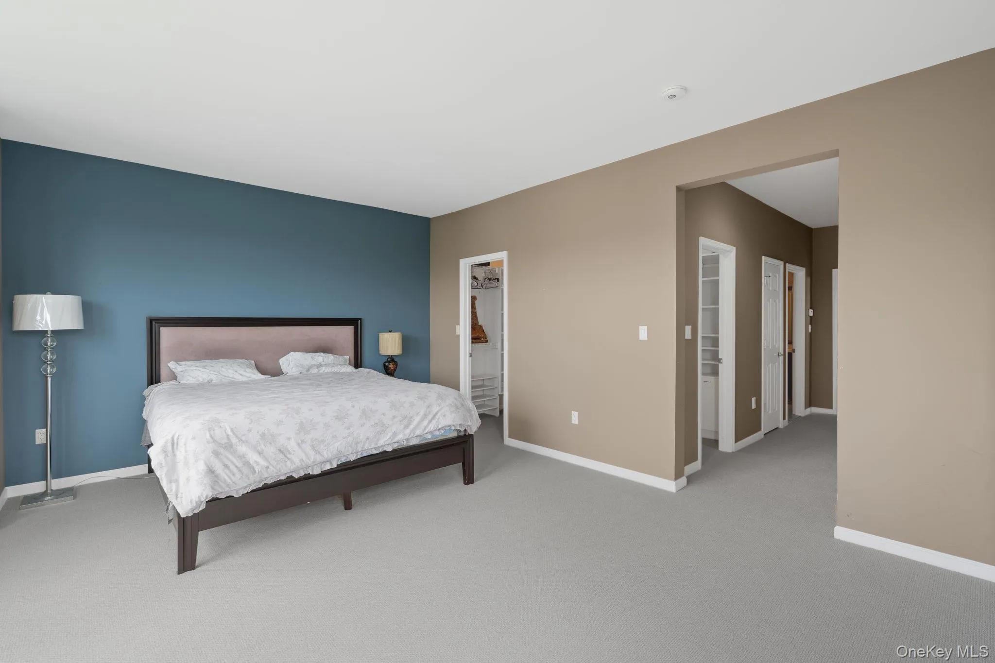 Carpeted bedroom featuring a spacious closet and a closet Carpeted bedroom featuring a spacious closet and a closet