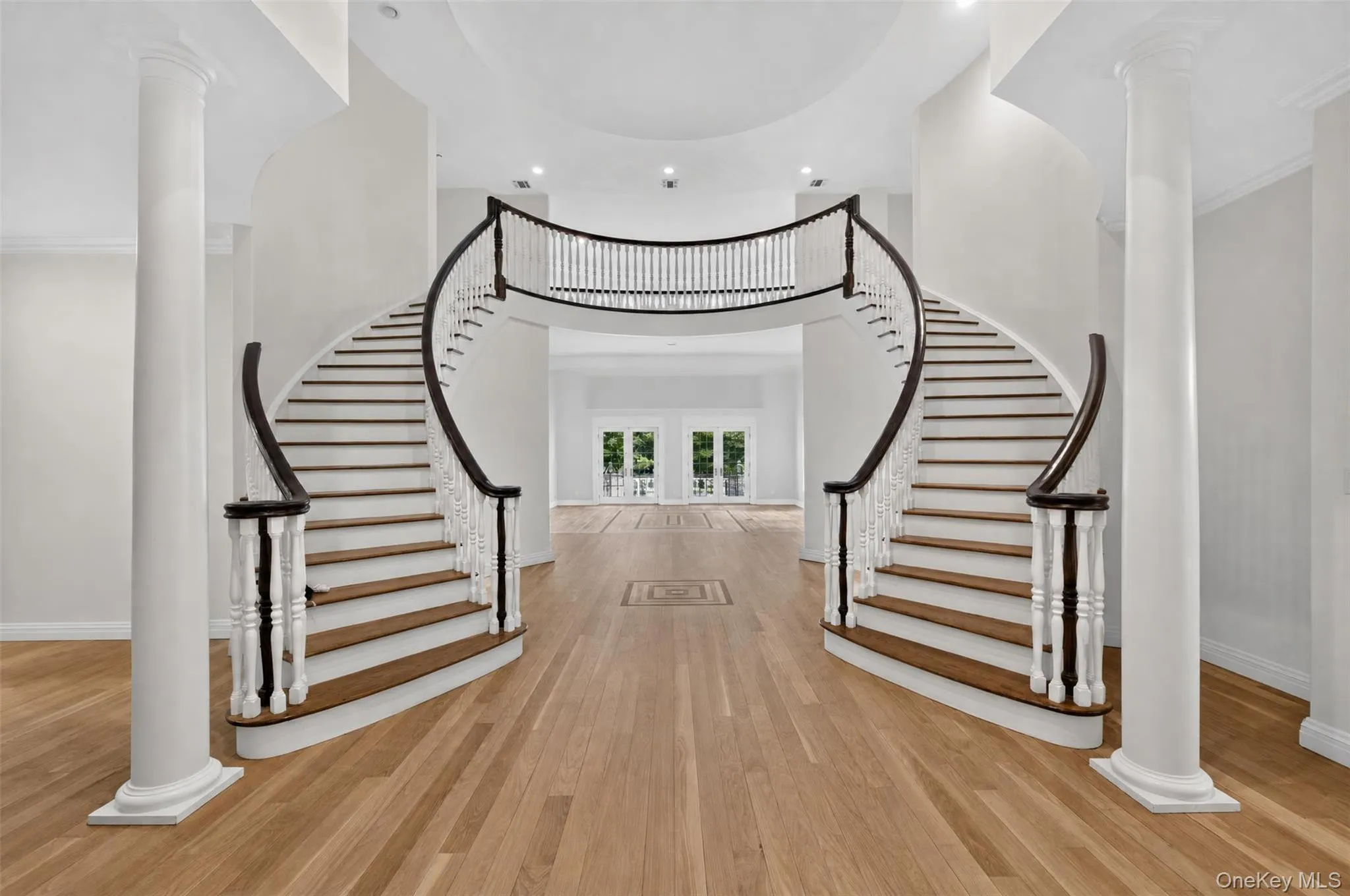 Two-story entrance foyer with double bridal staircase Two-story entrance foyer with double bridal staircase