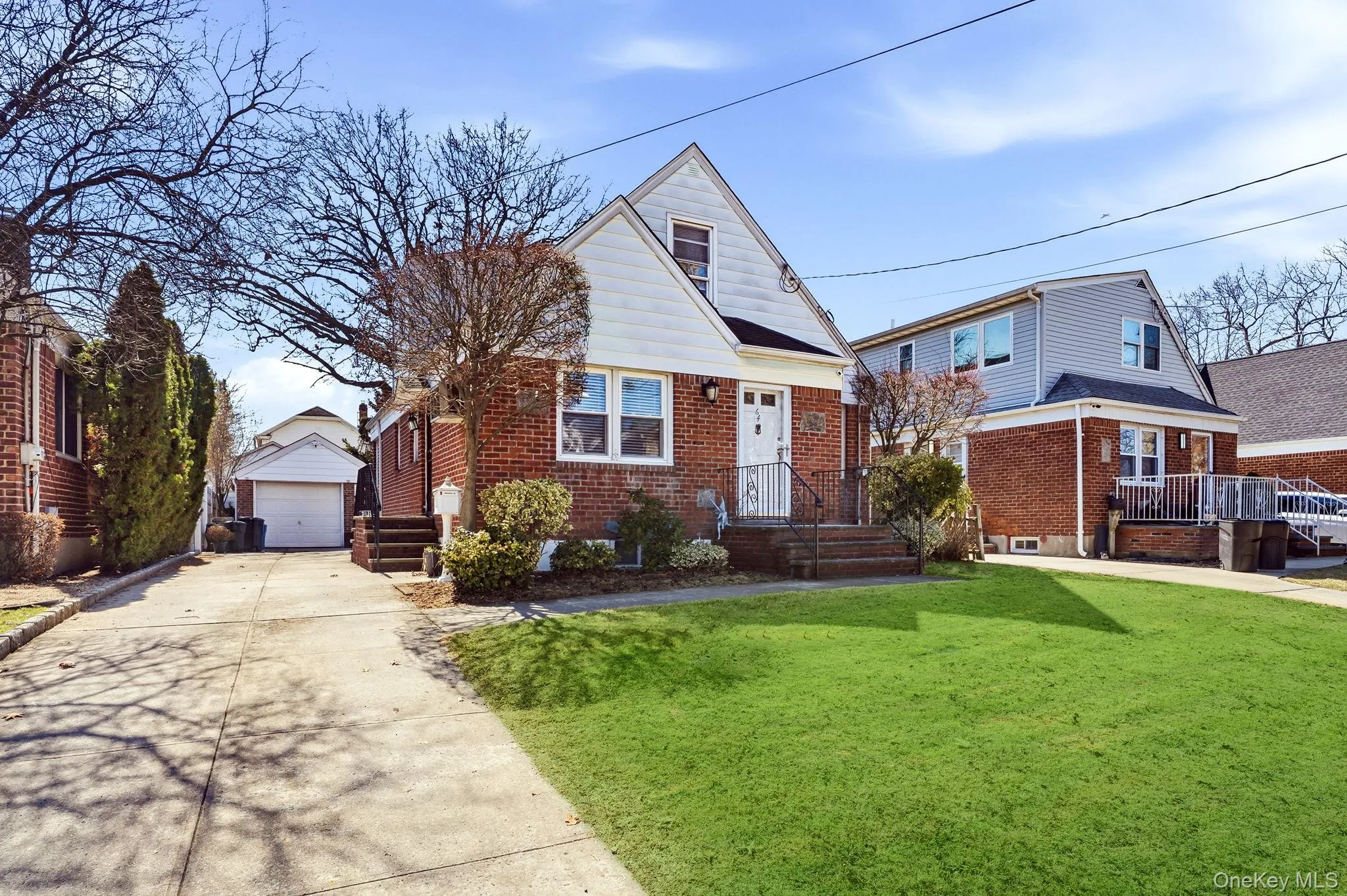 House with brick siding, an outbuilding, a detached garage, and a front lawn House with brick siding, an outbuilding, a detached garage, and a front lawn