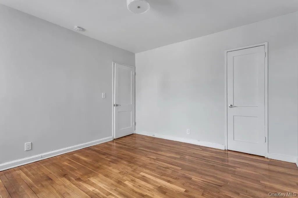 Unfurnished room featuring baseboards and wood finished floors Unfurnished room featuring baseboards and wood finished floors