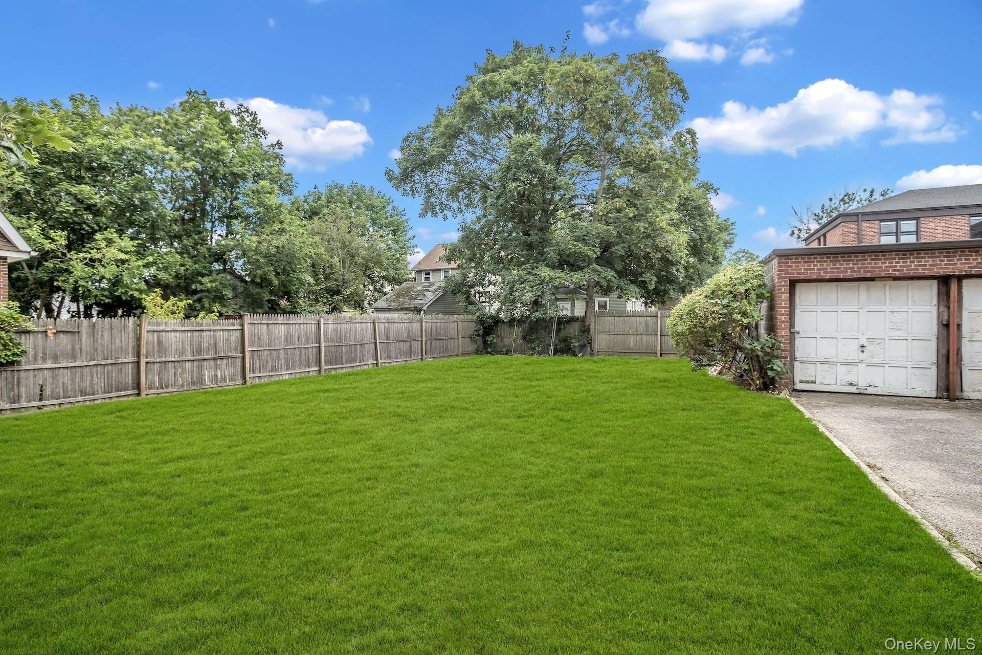 View of yard featuring a garage and a fenced backyard View of yard featuring a garage and a fenced backyard