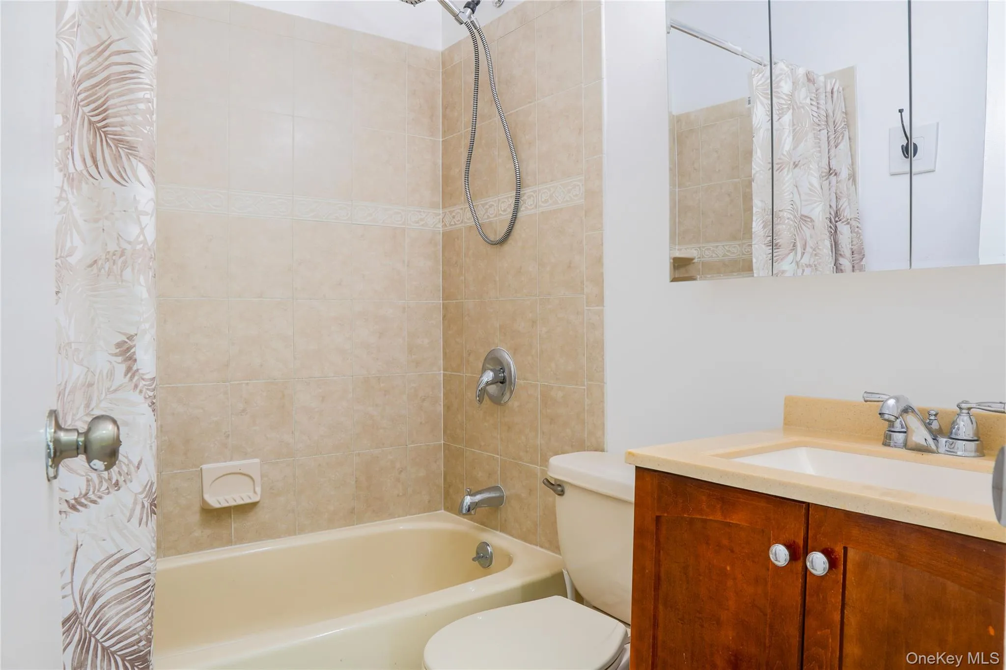 Shared/hall full bathroom with laundry tucked behind the door. Shared/hall full bathroom with laundry tucked behind the door.