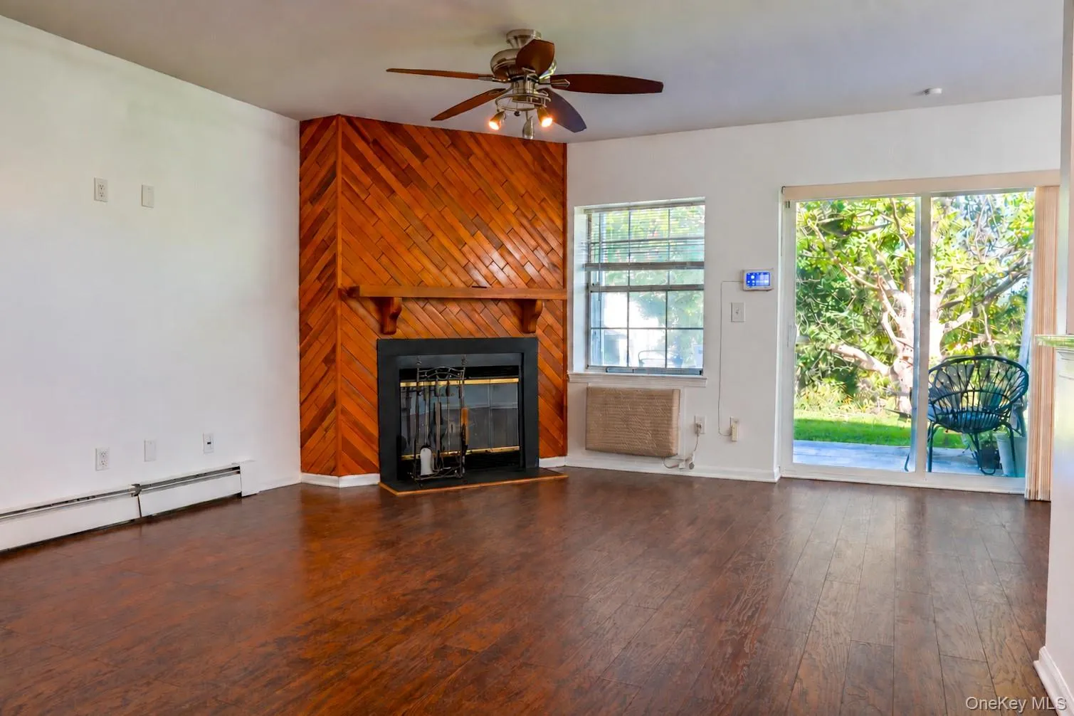 Living room with a fireplace and sliding doors to the patio. Living room with a fireplace and sliding doors to the patio.