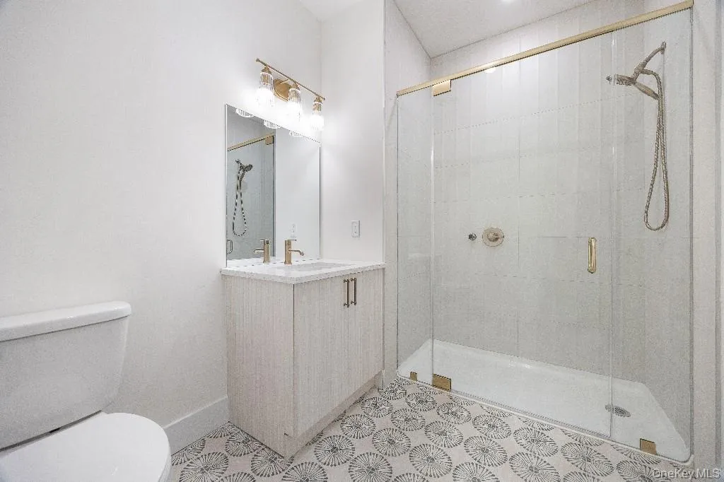 Bathroom featuring vanity, toilet, and walk in shower Bathroom featuring vanity, toilet, and walk in shower