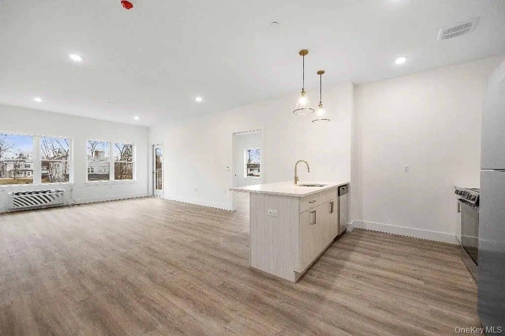 Kitchen with sink, stainless steel dishwasher, decorative light fixtures, and light hardwood / wood-style flooring Kitchen with sink, stainless steel dishwasher, decorative light fixtures, and light hardwood / wood-style flooring