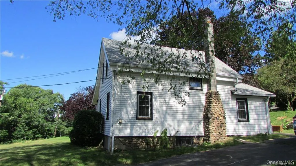 Back of house featuring stone chimney Back of house featuring stone chimney
