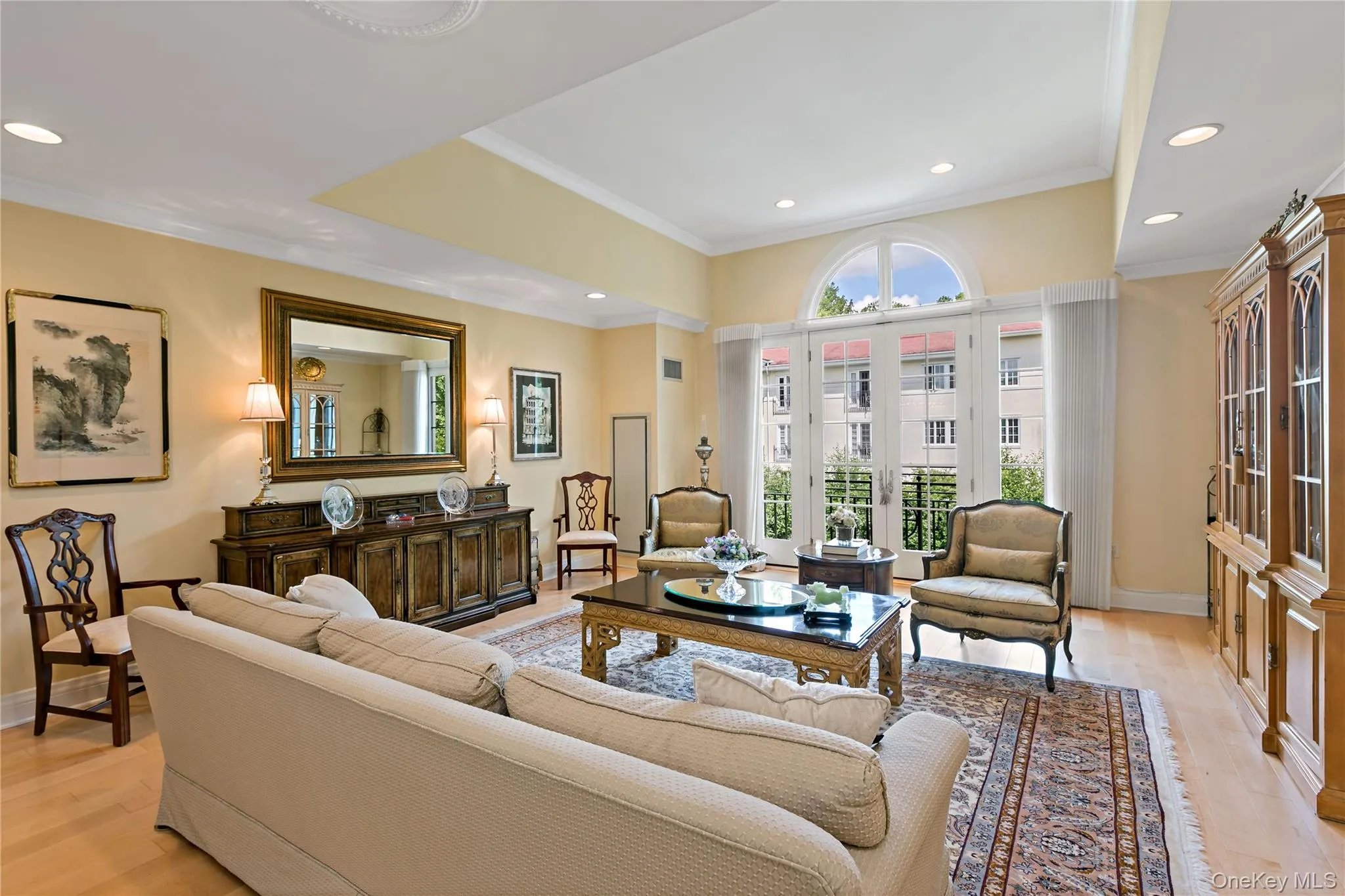 Dramatic 14-foot tray ceiling, walls of windows and a Palladian window with doors opening to a Juliette balcony, filling the space with natural light. Dramatic 14-foot tray ceiling, walls of windows and a Palladian window with doors opening to a Juliette balcony, filling the space with natural light.