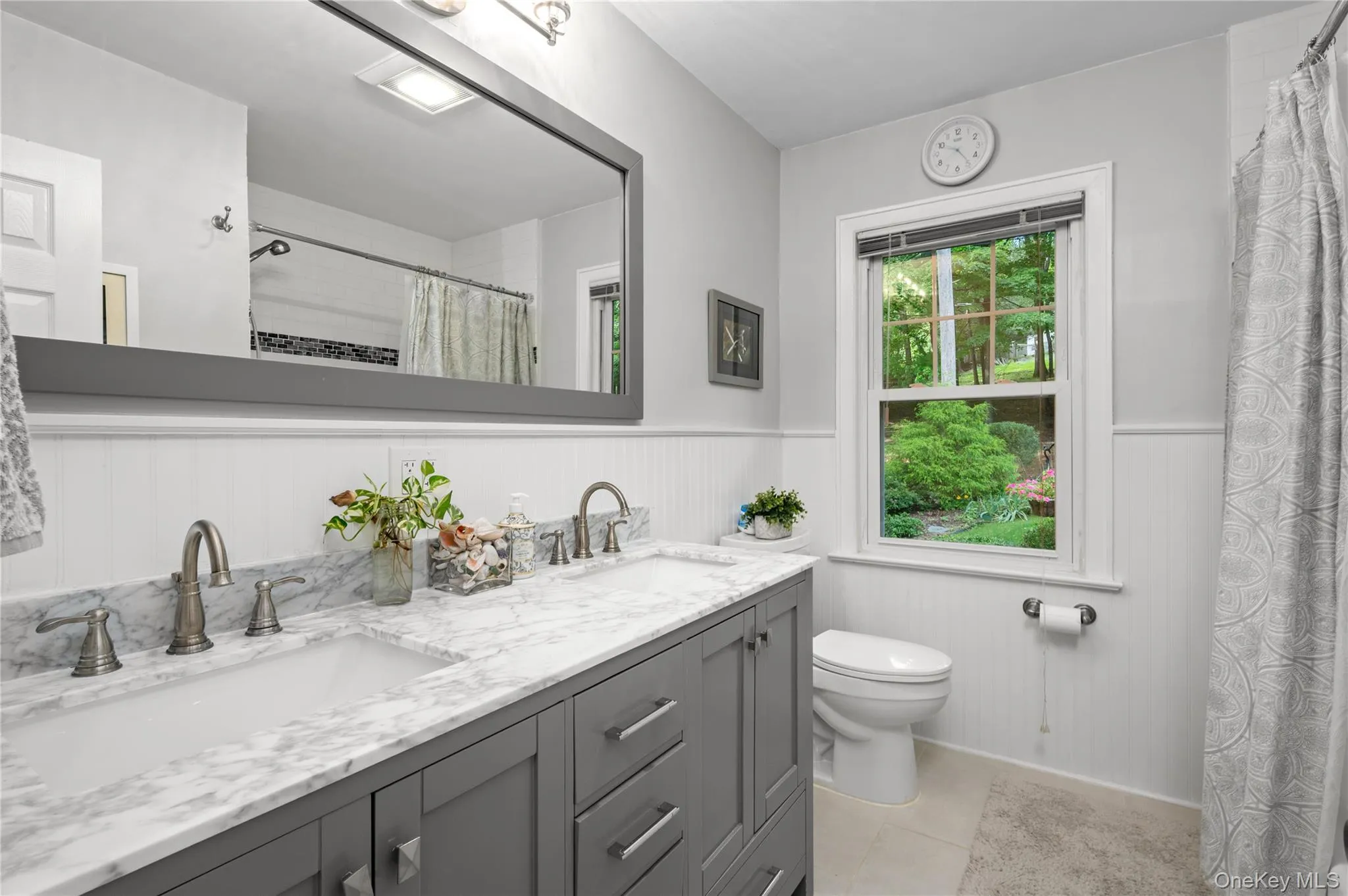 Updated first-floor bathroom featuring a double vanity and bathtub. Updated first-floor bathroom featuring a double vanity and bathtub.