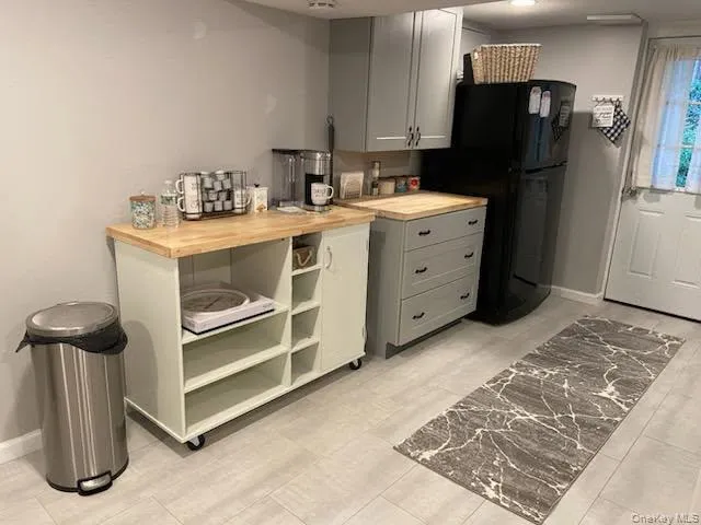 Kitchen featuring gray cabinets and freestanding refrigerator Kitchen featuring gray cabinets and freestanding refrigerator