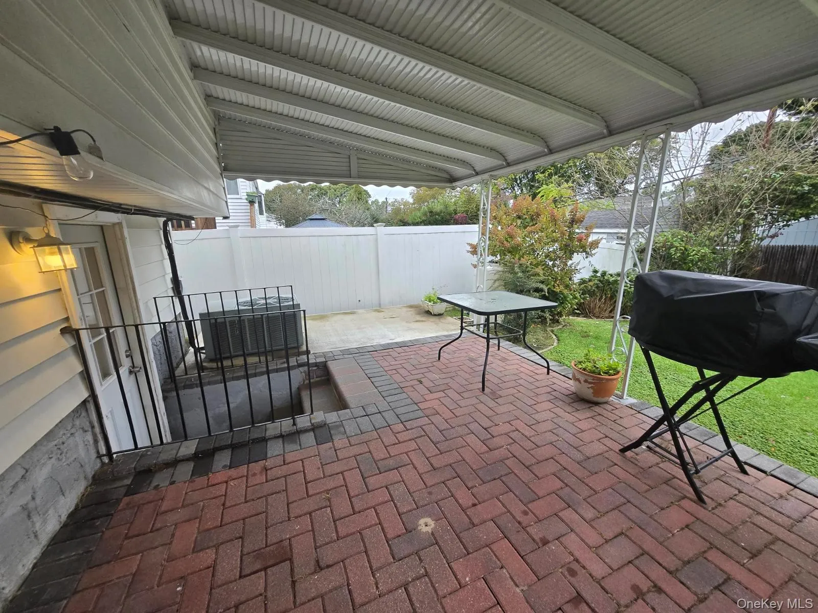 Fenced backyard featuring a patio area and a grill Fenced backyard featuring a patio area and a grill