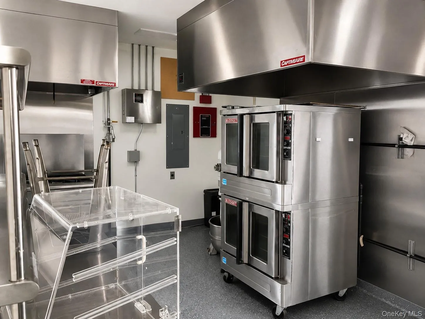 Commercial-grade kitchen featuring stainless steel appliances, extensive stainless steel countertops, and industrial lighting Commercial-grade kitchen featuring stainless steel appliances, extensive stainless steel countertops, and industrial lighting