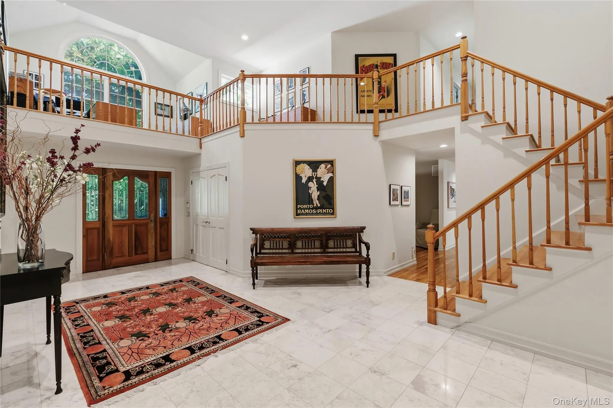 Two-story elegant marble entry foyer showing view of loft/library area atop the staircase. Off the foyer you will find a powder room, laundry and pantry. Two-story elegant marble entry foyer showing view of loft/library area atop the staircase. Off the foyer you will find a powder room, laundry and pantry.