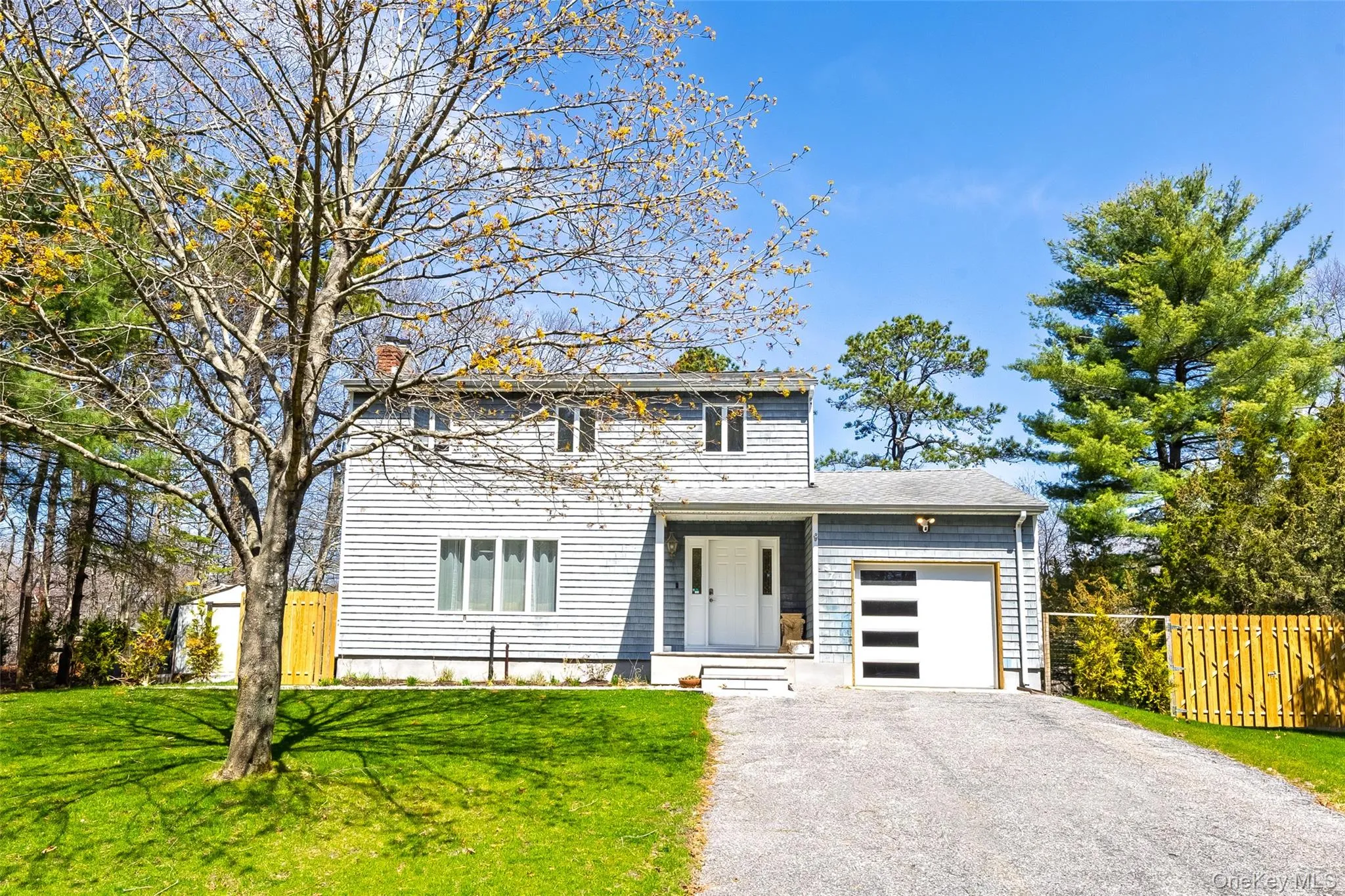 View of front of house featuring a garage, a chimney, and asphalt driveway View of front of house featuring a garage, a chimney, and asphalt driveway