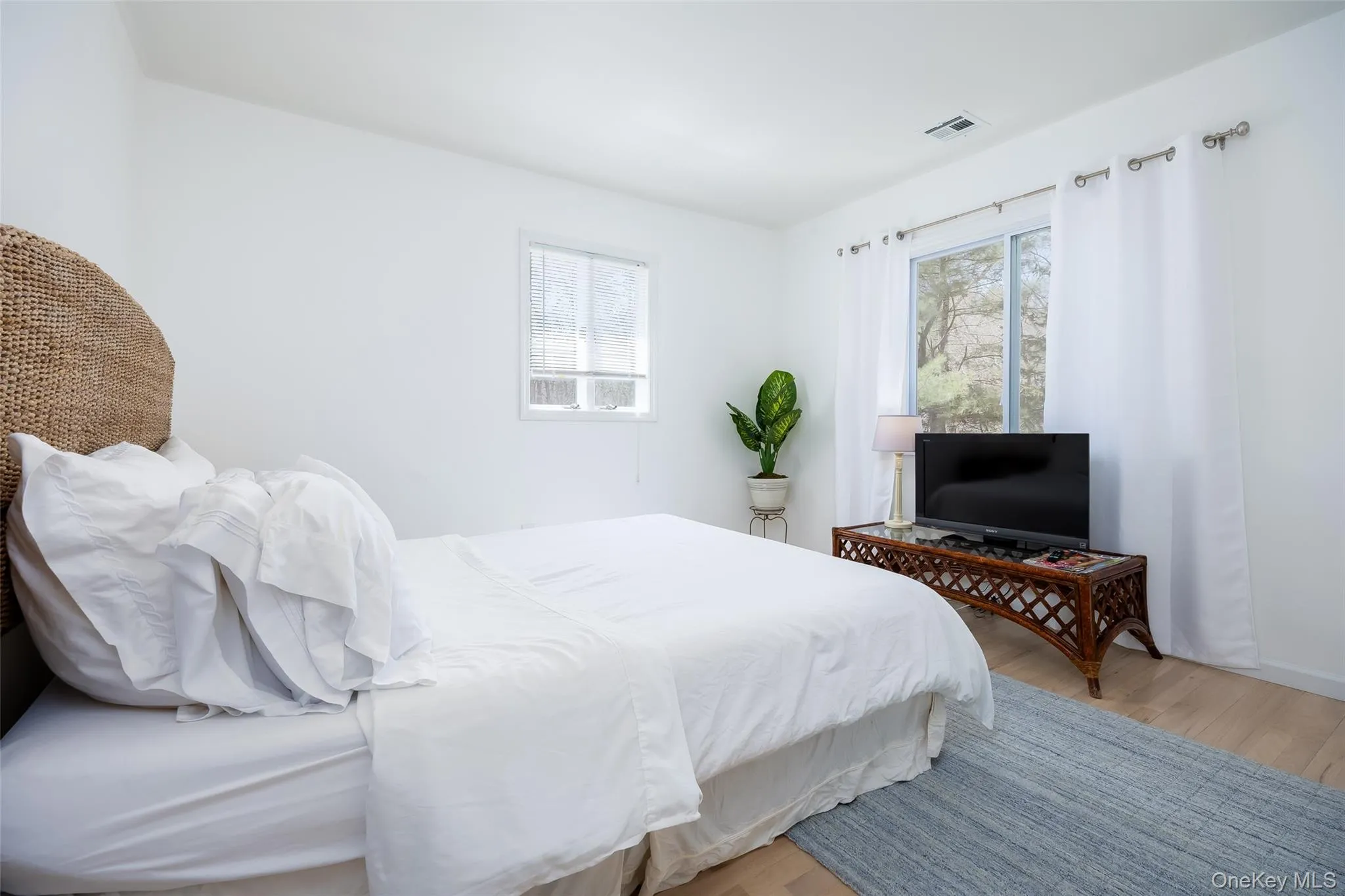 Bedroom featuring multiple windows and wood finished floors Bedroom featuring multiple windows and wood finished floors